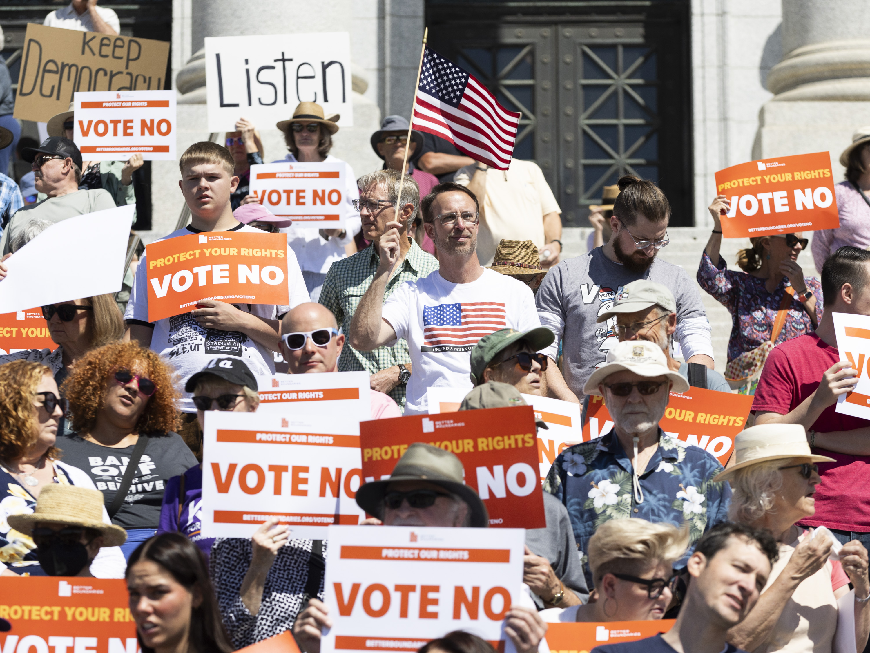 Supporters with signs stand on the Utah Capitol steps during a rally by Better Boundaries in Salt Lake City on Monday.