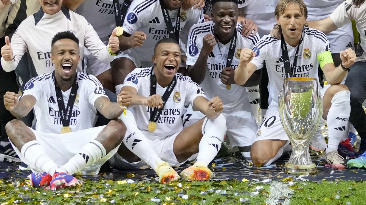 Real Madrid's Eder Militao, Kylian Mbappe, Vinicius Junior, and Luka Modric pose with the trophy after winning the UEFA Super Cup Final soccer match between Real Madrid and Atalanta at the Narodowy stadium in Warsaw, Poland, Wednesday, Aug. 14, 2024. Real Madrid won 2-0.