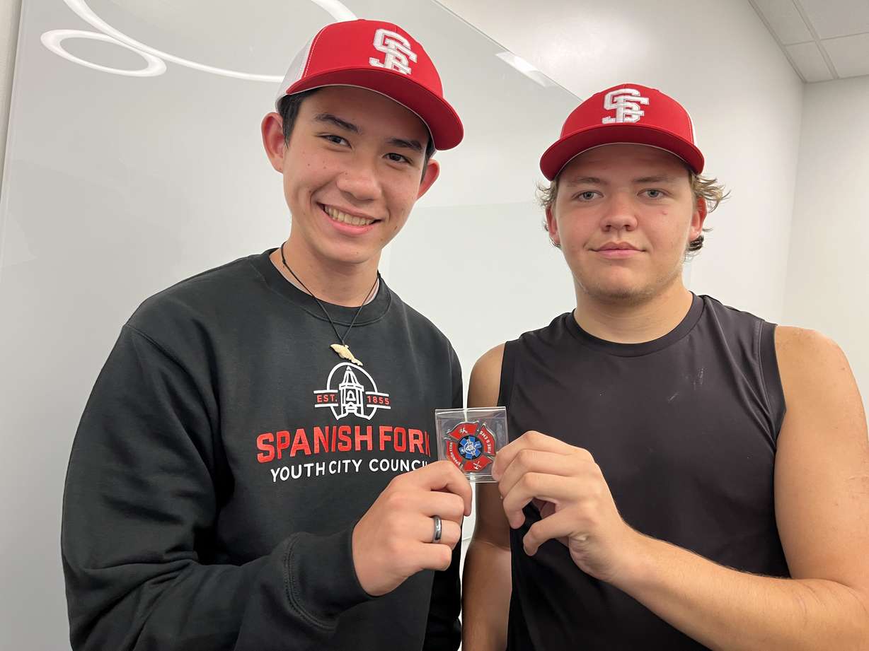Spanish Fork High students PJ Merrill and Trayven Elquist show the coin they received from the Spanish Fork Fire Department after responding with their knowledge to a cardiac arrest patient on Saturday at Spanish Fork Sports Park.