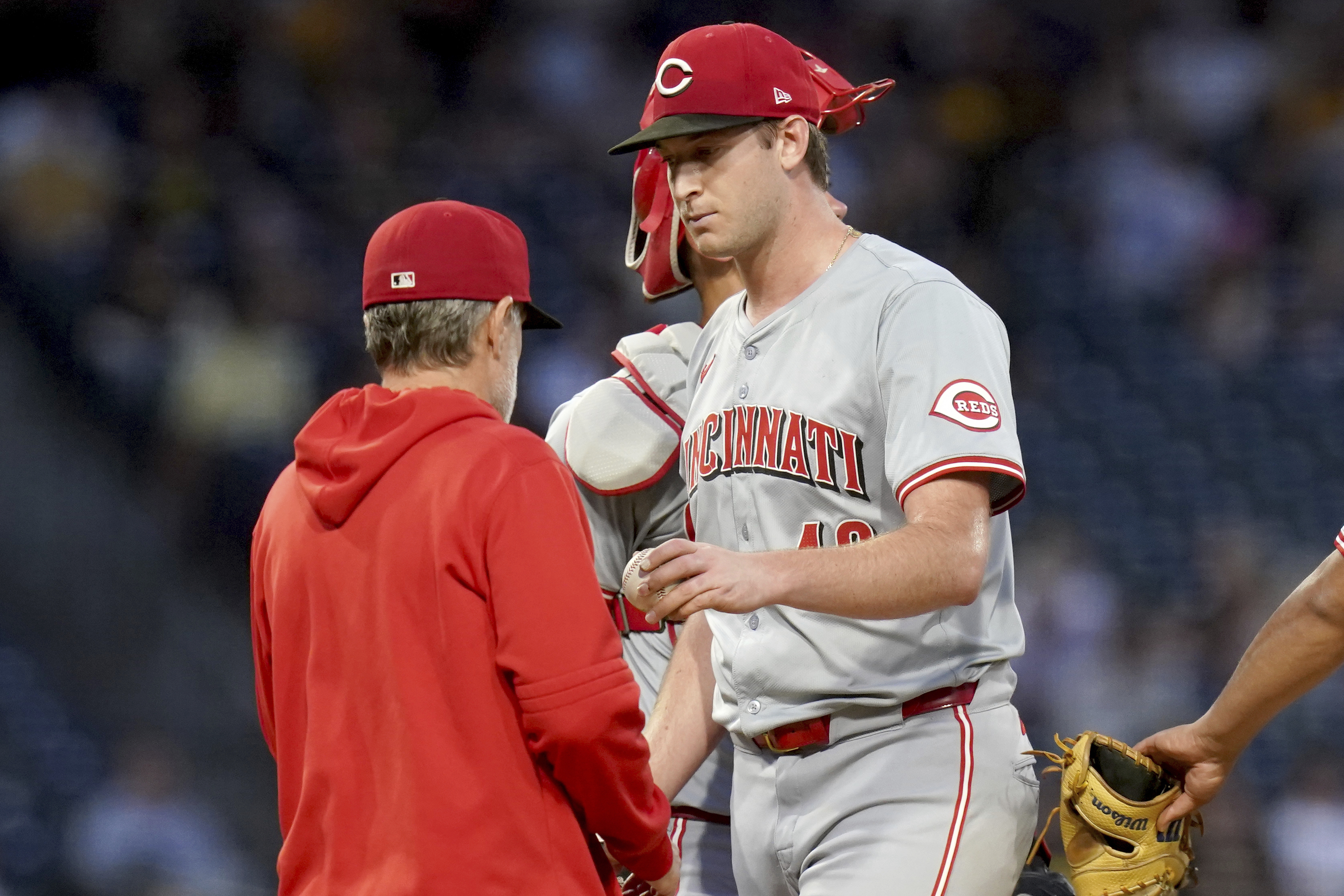 Cincinnati Reds starting pitcher Nick Lodolo, right, hands the ball to manager David Bell, left, during the fifth inning of a baseball game against the Pittsburgh Pirates, Thursday, Aug. 22, 2024, in Pittsburgh.