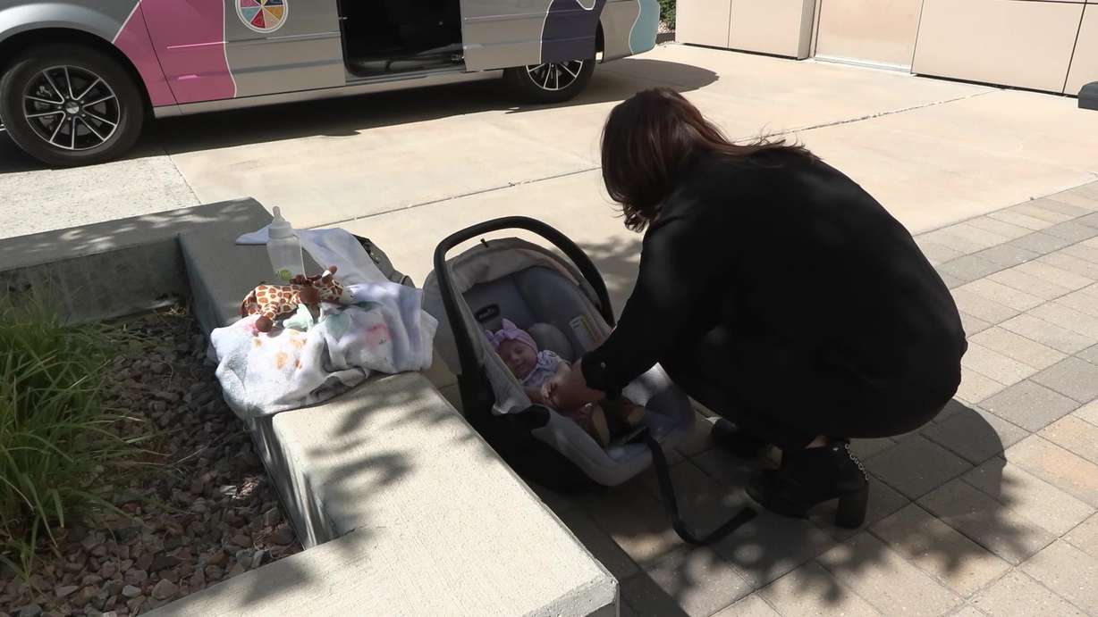 Jillian Davis places her baby Glacier Lu inside of a safe car seat.