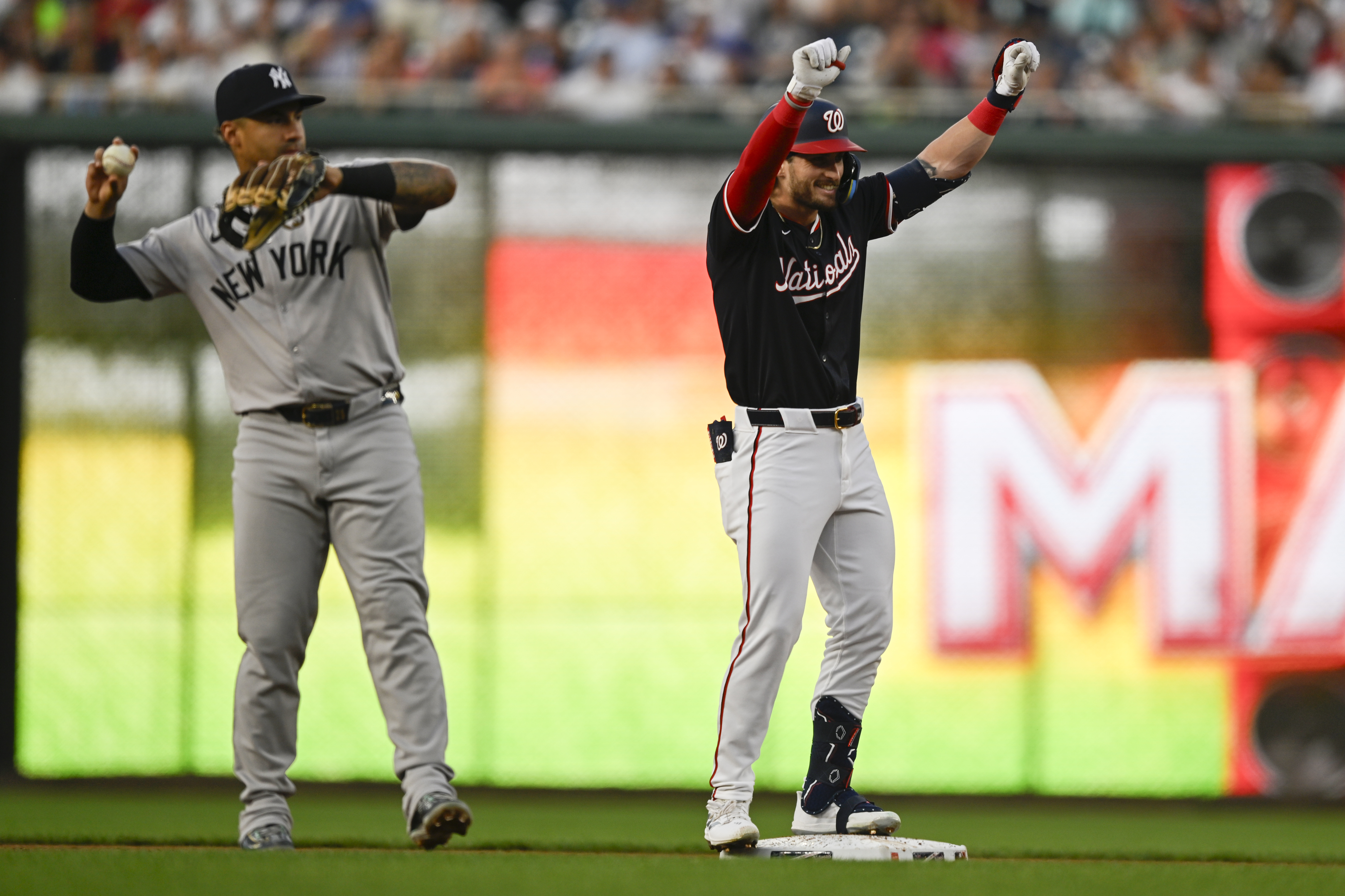 New York Yankees second baseman Gleyber Torres throws the ball as Washington Nationals' Dylan Crews celebrates his first major league hit at second base during the second inning of a baseball game, Tuesday, Aug. 27, 2024, in Washington. 