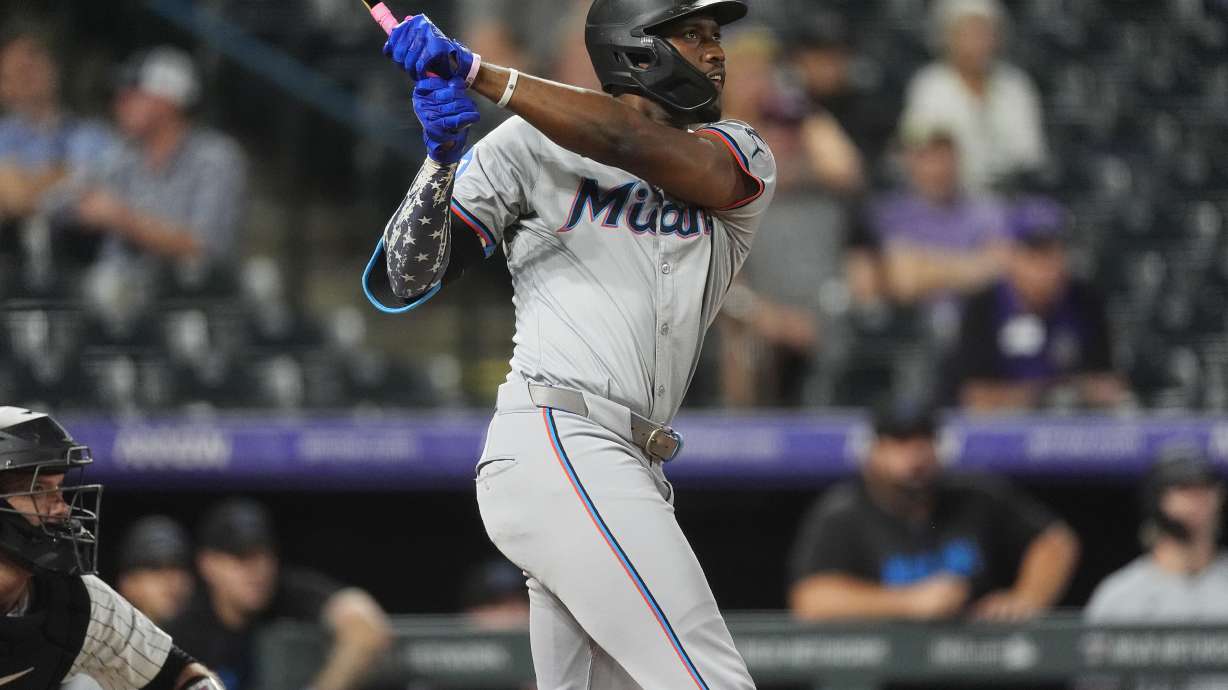Miami Marlins' Jesus Sanchez follows the flight of his three-run home run off Colorado Rockies relief pitcher Angel Chivilli in the ninth inning of after a baseball game, Tuesday, Aug. 27, 2024, in Denver.