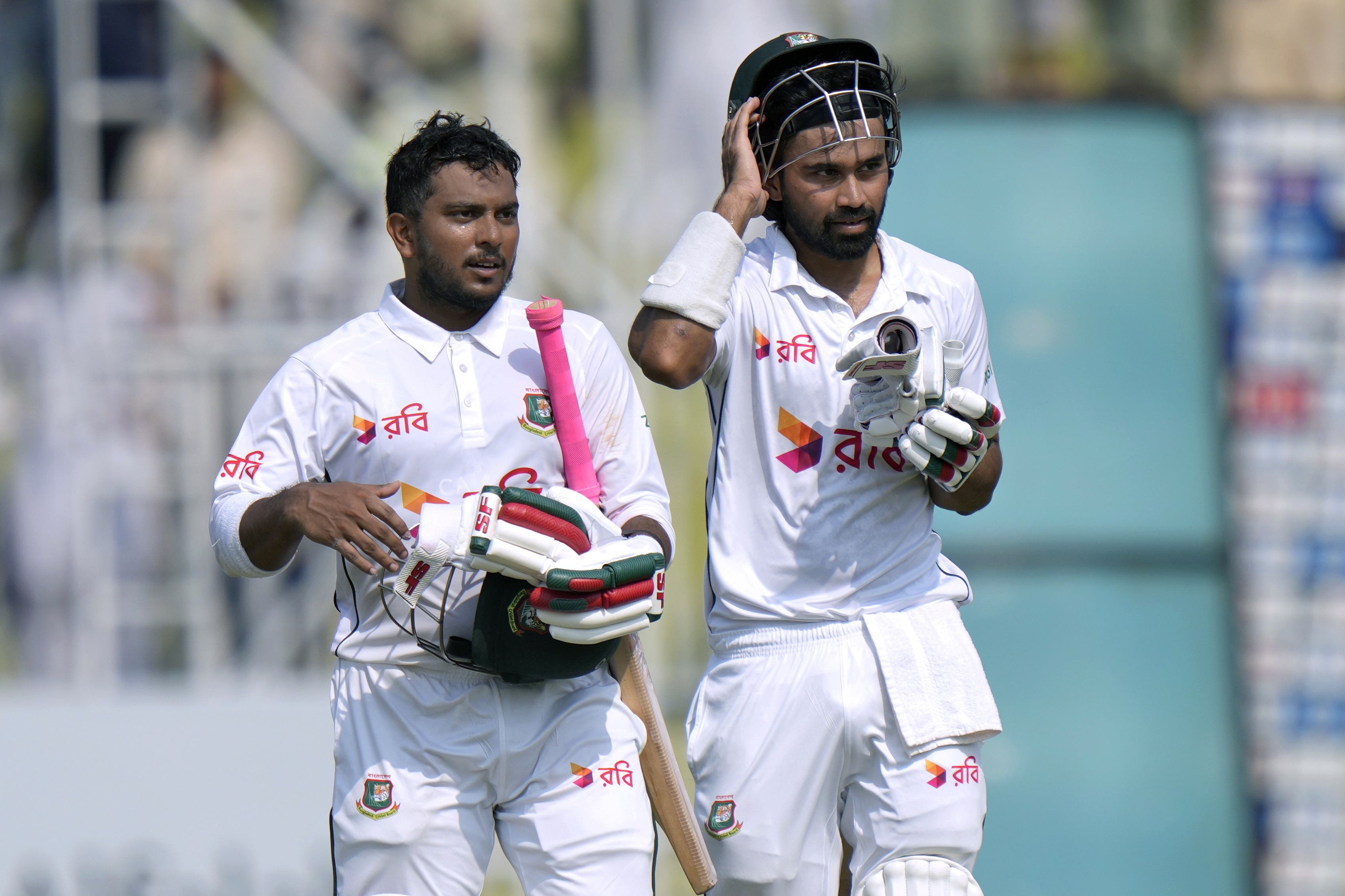 Bangladesh's Shadman Islam, right, and Zakir Hasan walks off the field after winning first test cricket match against Pakistan, in Rawalpindi, Pakistan, Sunday, Aug. 25, 2024. 