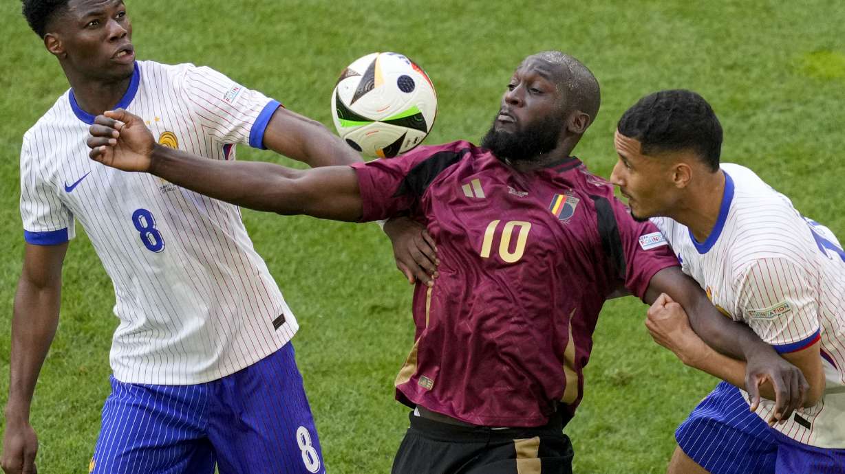FILE - Belgium's Romelu Lukaku is challenged by Aurelien Tchouameni of France and William Saliba of France during a round of sixteen match between France and Belgium at the Euro 2024 soccer tournament in Duesseldorf, Germany, Monday, July 1, 2024.