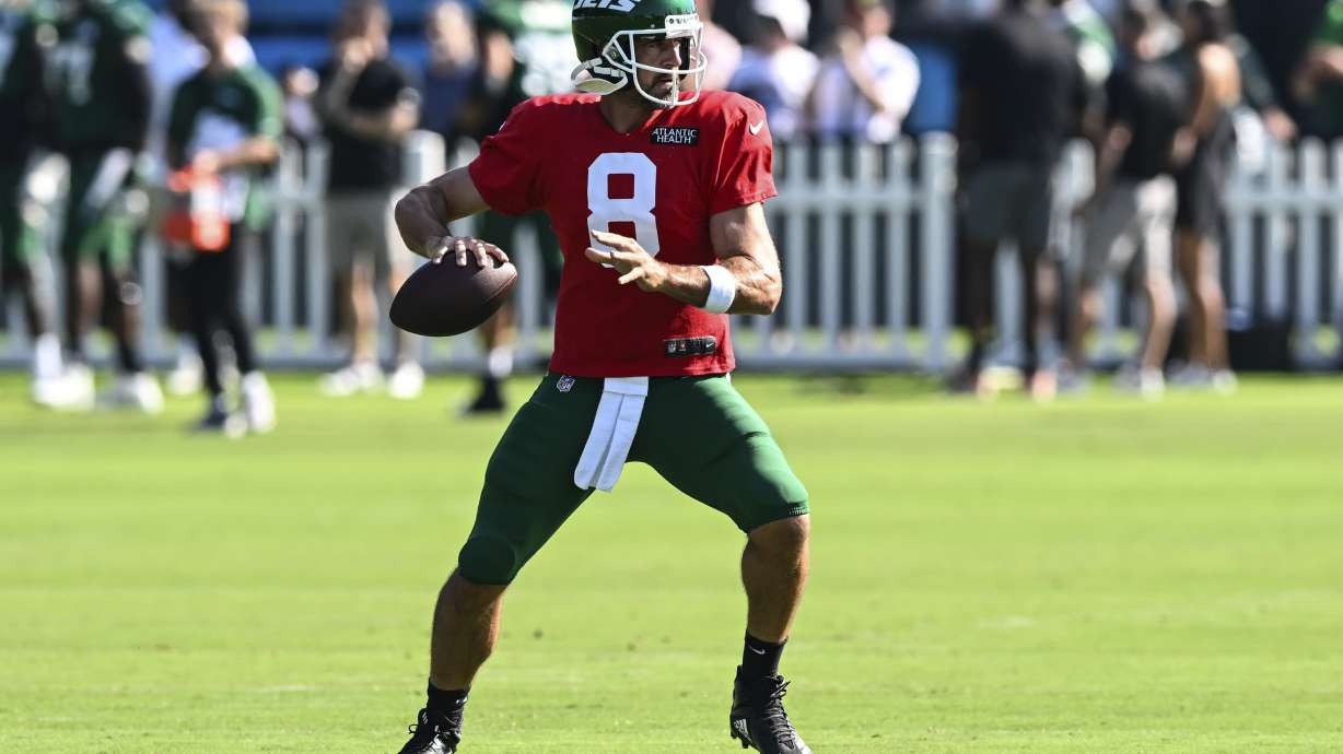 New York Jets quarterback Aaron Rodgers drops back to throw a pass during an NFL football joint practice with the Carolina Panthers Thursday, Aug. 15, 2024, in Charlotte, N.C.