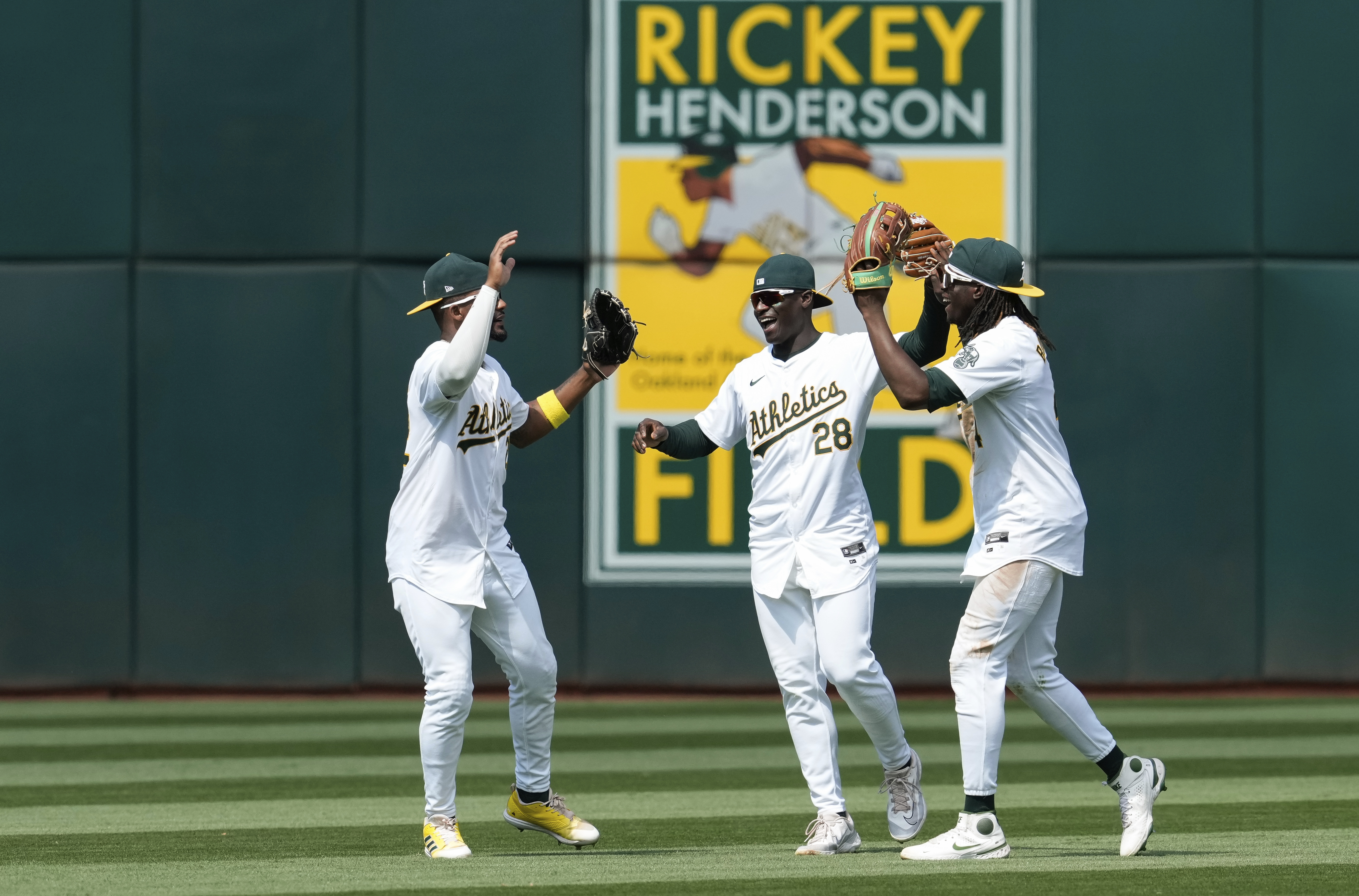 From left to right, Oakland Athletics outfielders Miguel Andujar, Daz Cameron and Lawrence Butler celebrate after their victory over the Tampa Bay Rays in a baseball game Thursday, Aug. 22, 2024, in Oakland, Calif. 
