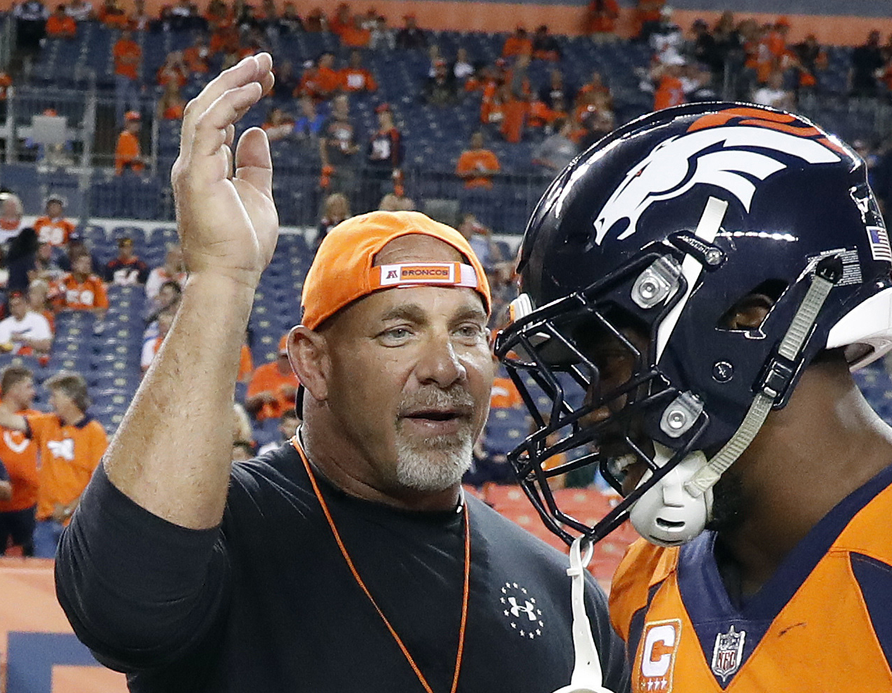 FILE - In this Sept. 11, 2017, file photo, professional wrestler Bill Goldberg, left, greets Denver Broncos outside linebacker Von Miller prior to an NFL football game against the Los Angeles Chargers in Denver.