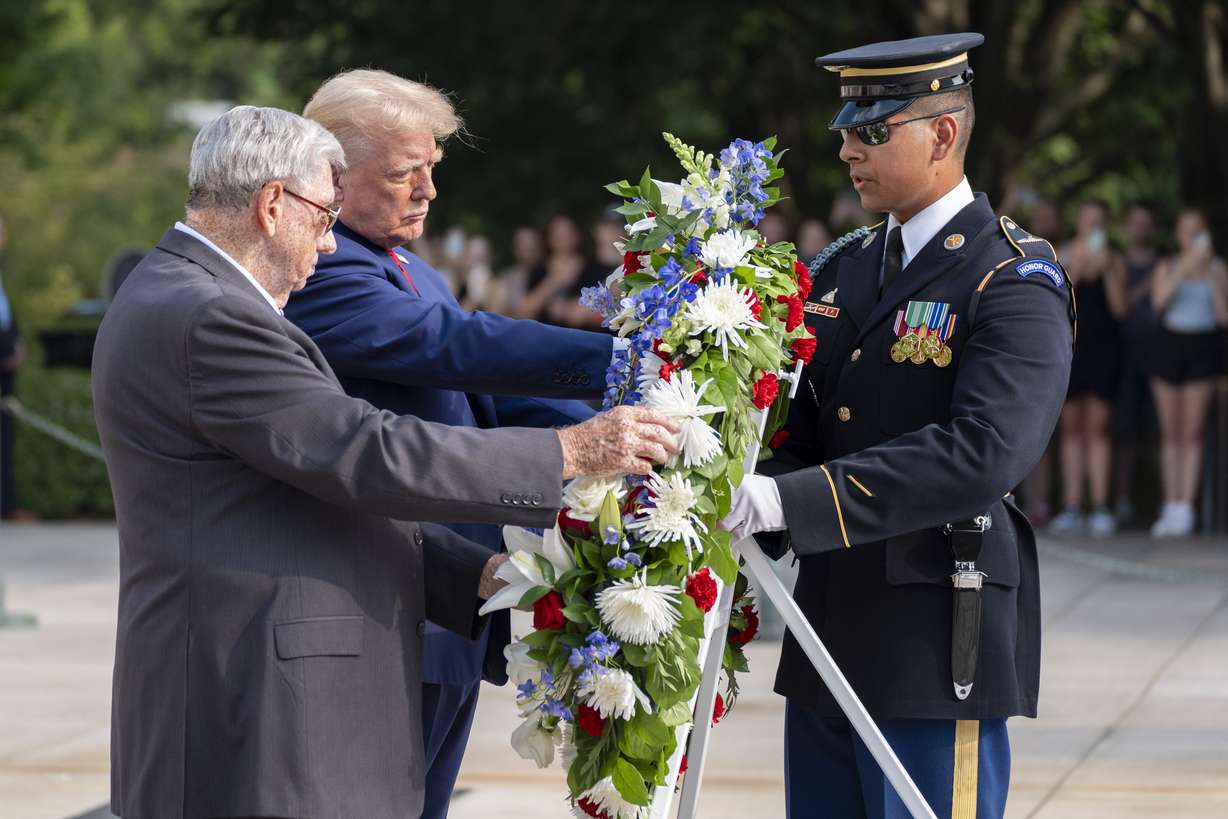 Bill Barnett, left, grandfather of Staff Sgt. Darin Taylor Hoover, and Republican presidential nominee former President Donald Trump place a wreath at the Tomb of the Unknown Solider in honor of Hoover at Arlington National Cemetery, Monday, in Arlington, Va.
