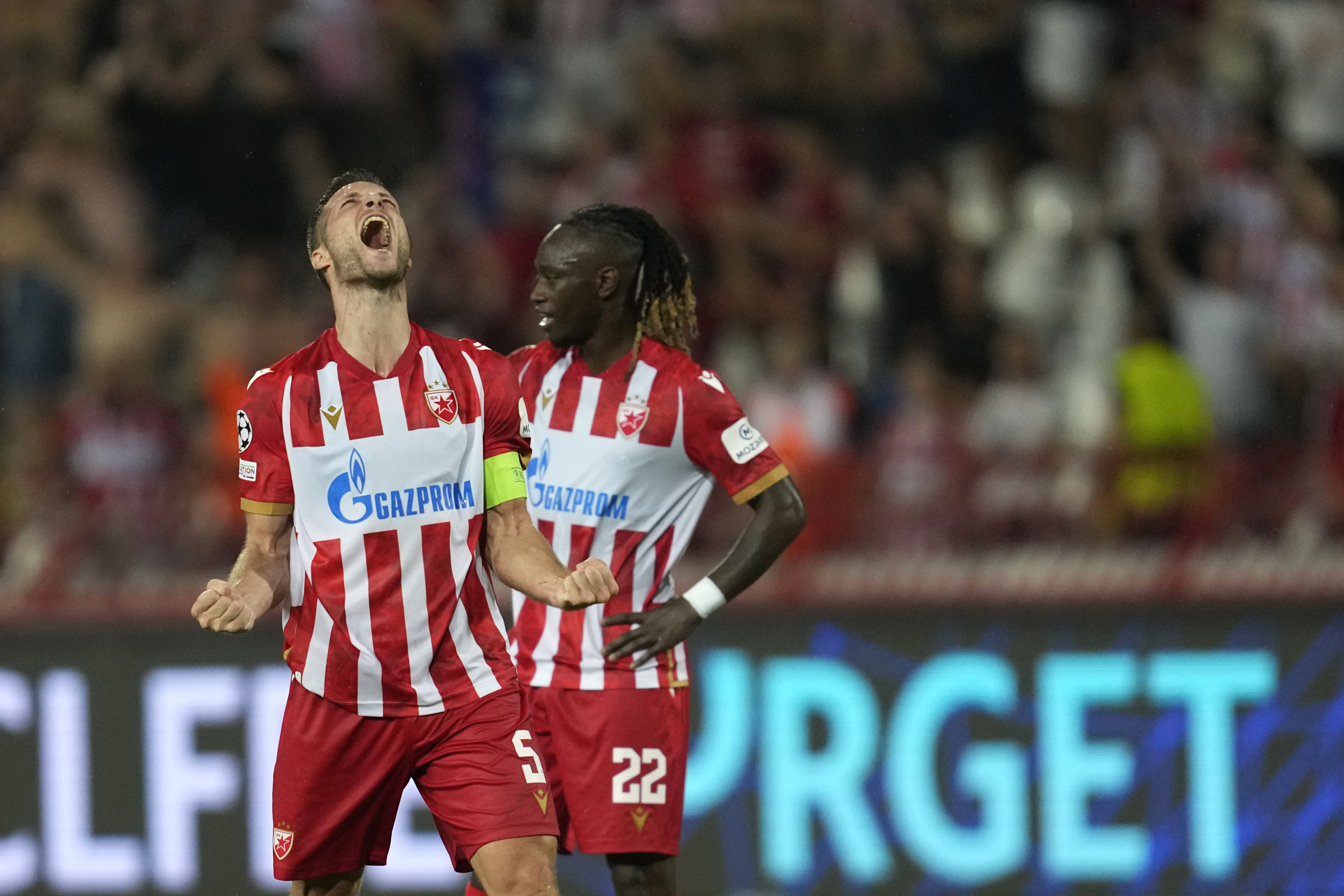 Red Star's Uros Spajic, left, and Red Star's Dalcio Gomes celebrate their victory at the Champions League play-off second leg soccer match between Red Star and Bodo Glimt, at the Rajko Mitic Stadium, in Belgrade, Serbia, Wednesday, Aug. 28, 2024. 