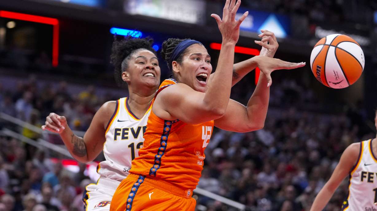 Indiana Fever forward Damiris Dantas (12) \knocks the ball away from Connecticut Sun forward Brionna Jones (42) in the first half of a WNBA basketball game in Indianapolis, Wednesday, Aug. 28, 2024.