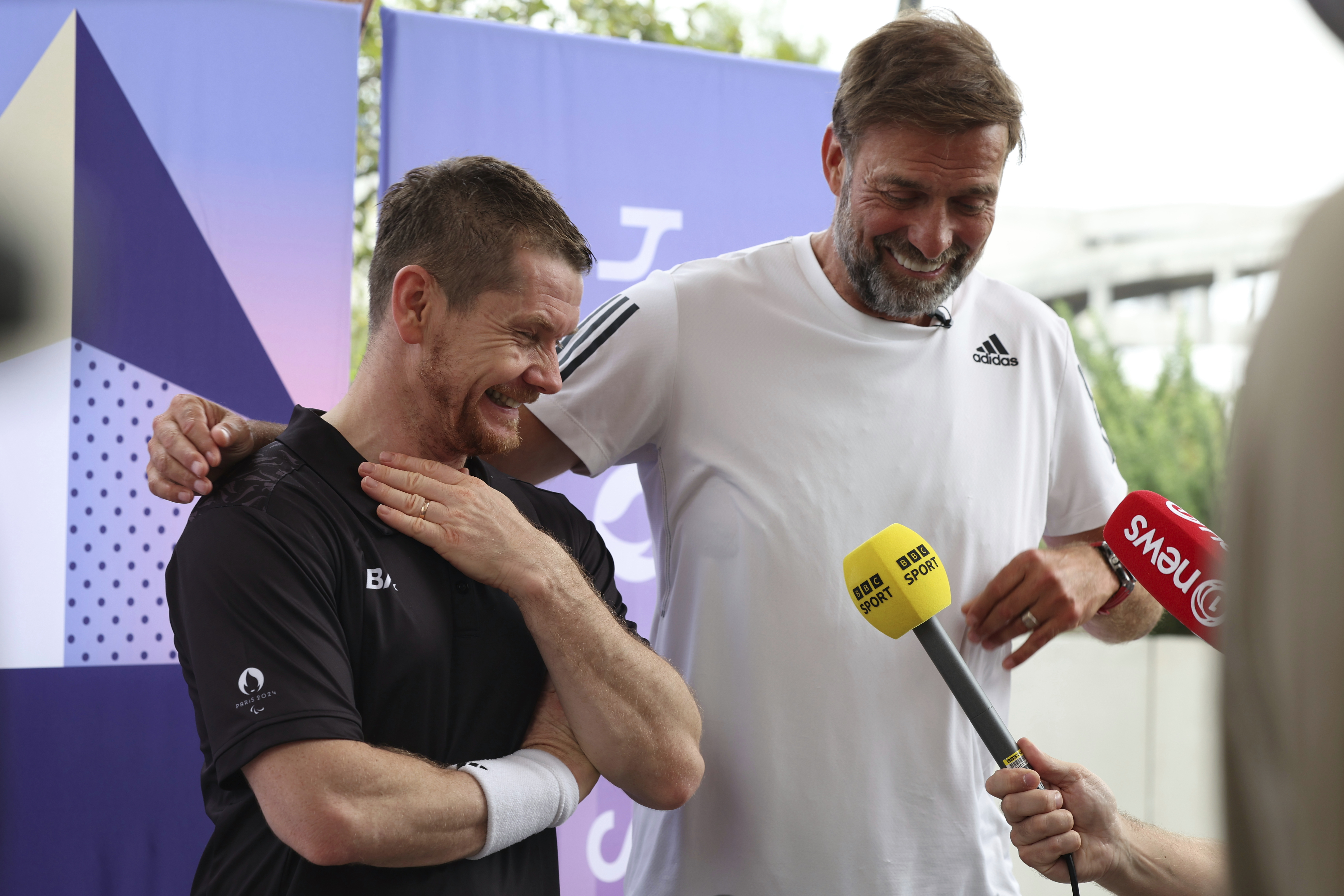 German football manager Jurgen Klopp, right, and para badminton player Wojtek Czyz react as they discuss the results of Czyz's match in Porte La Chapelle Arena during the Paralympic Games on Wednesday, Aug. 28, 2024, in Paris. .