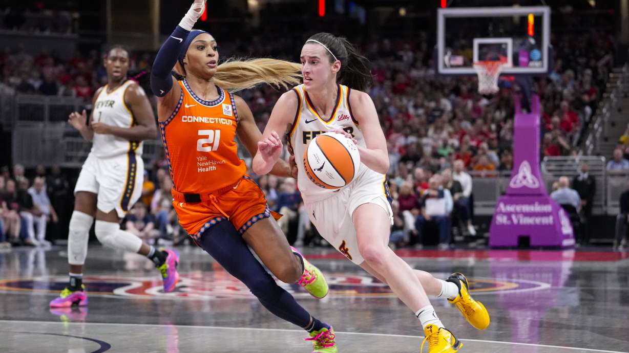 Indiana Fever guard Caitlin Clark (22) drives on Connecticut Sun guard DiJonai Carrington (21) in the second half of a WNBA basketball game in Indianapolis, Wednesday, Aug. 28, 2024.