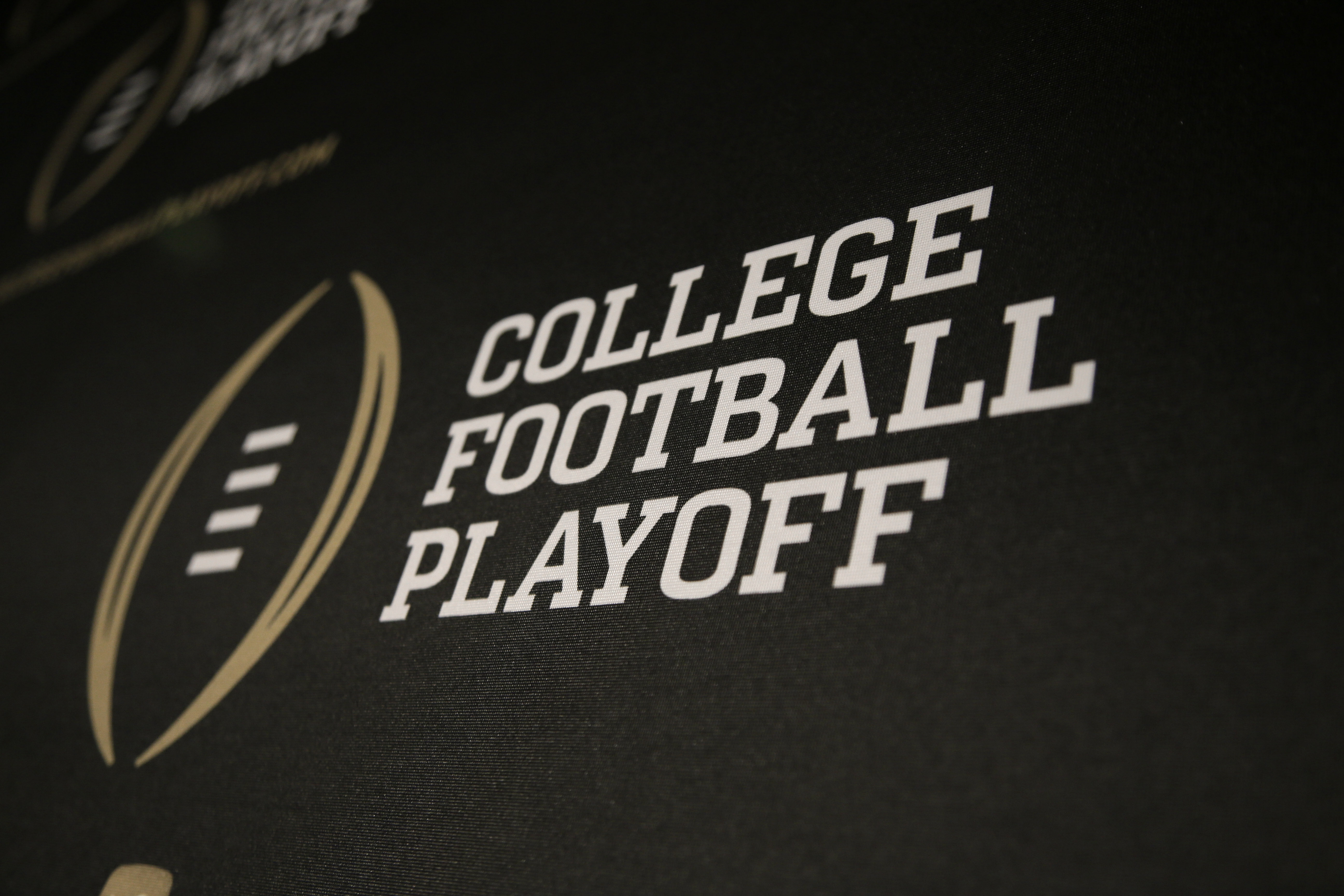 FILE - The College Football Playoff logo is printed across a backdrop during a news conference where the 13 members of the committee were announced, Wednesday, Oct. 16, 2013, in Irving, Texas.