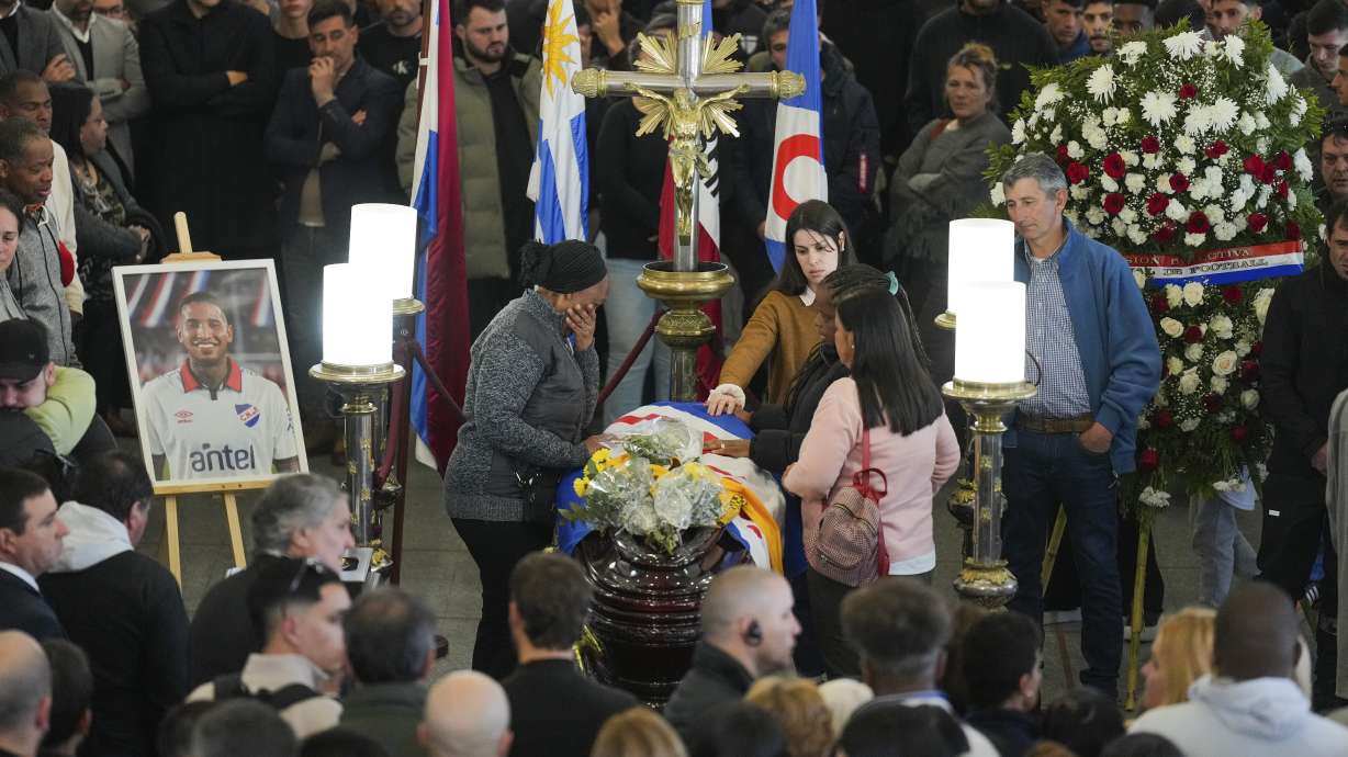 Family members of soccer player Juan Izquierdo stand by his coffin during a wake at his Nacional soccer club in Montevideo, Uruguay, Thursday, Aug. 29, 2024. Izquierdo died at a Brazilian hospital after collapsing on Aug. 22 during a Copa Libertadores soccer match between Nacional and Sao Paulo.