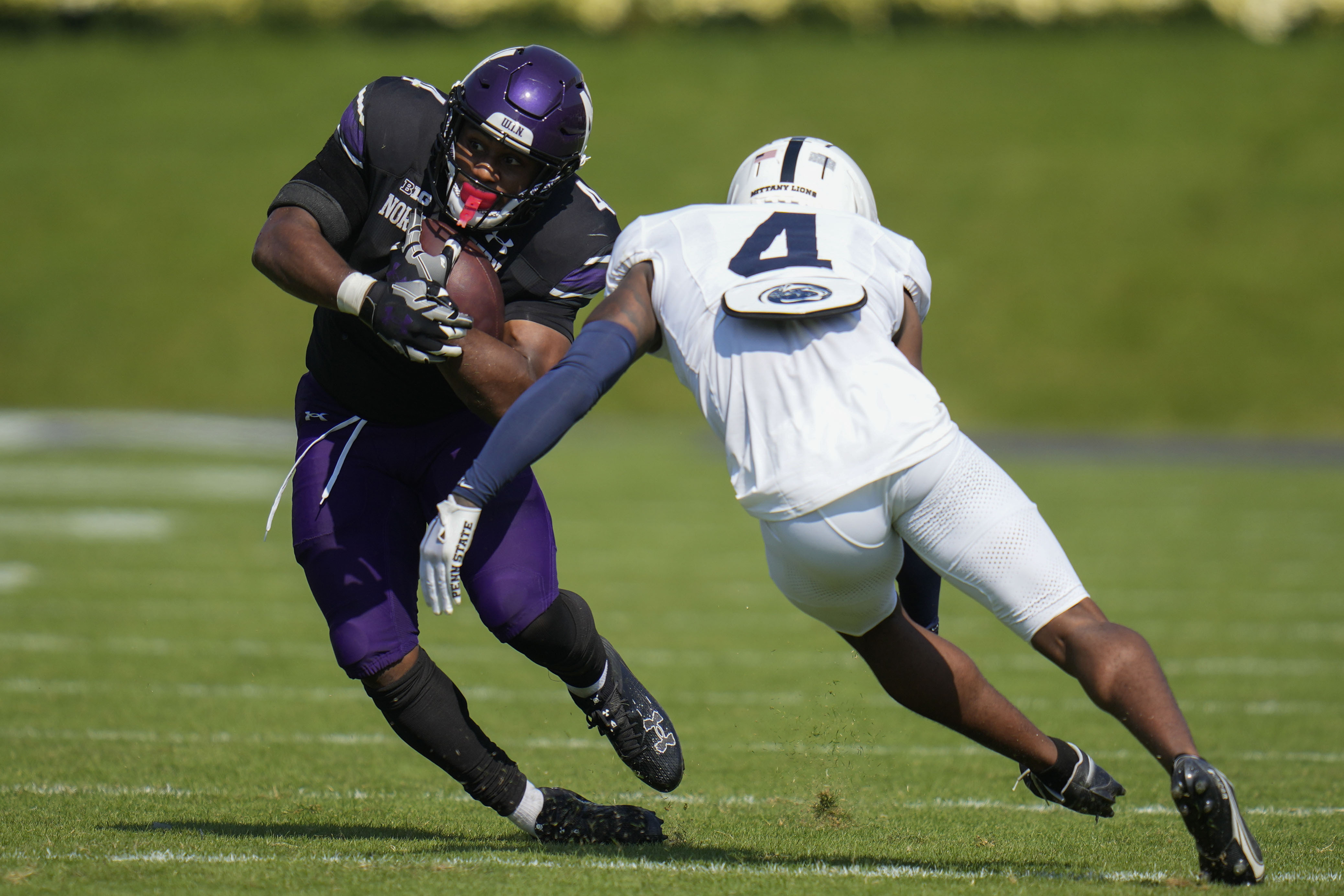 FILE - Northwestern running back Cam Porter, left, is tackled by Penn State cornerback Kalen King during the first half of an NCAA college football game, Sept. 30, 2023, in Evanston, Ill. 
