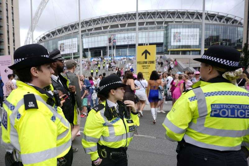 Police officers watch the arrival of Taylor Swift fans at Wembley Stadium in London, Aug. 15 on the first day of five concerts of Taylor Swift's Eras Tour.