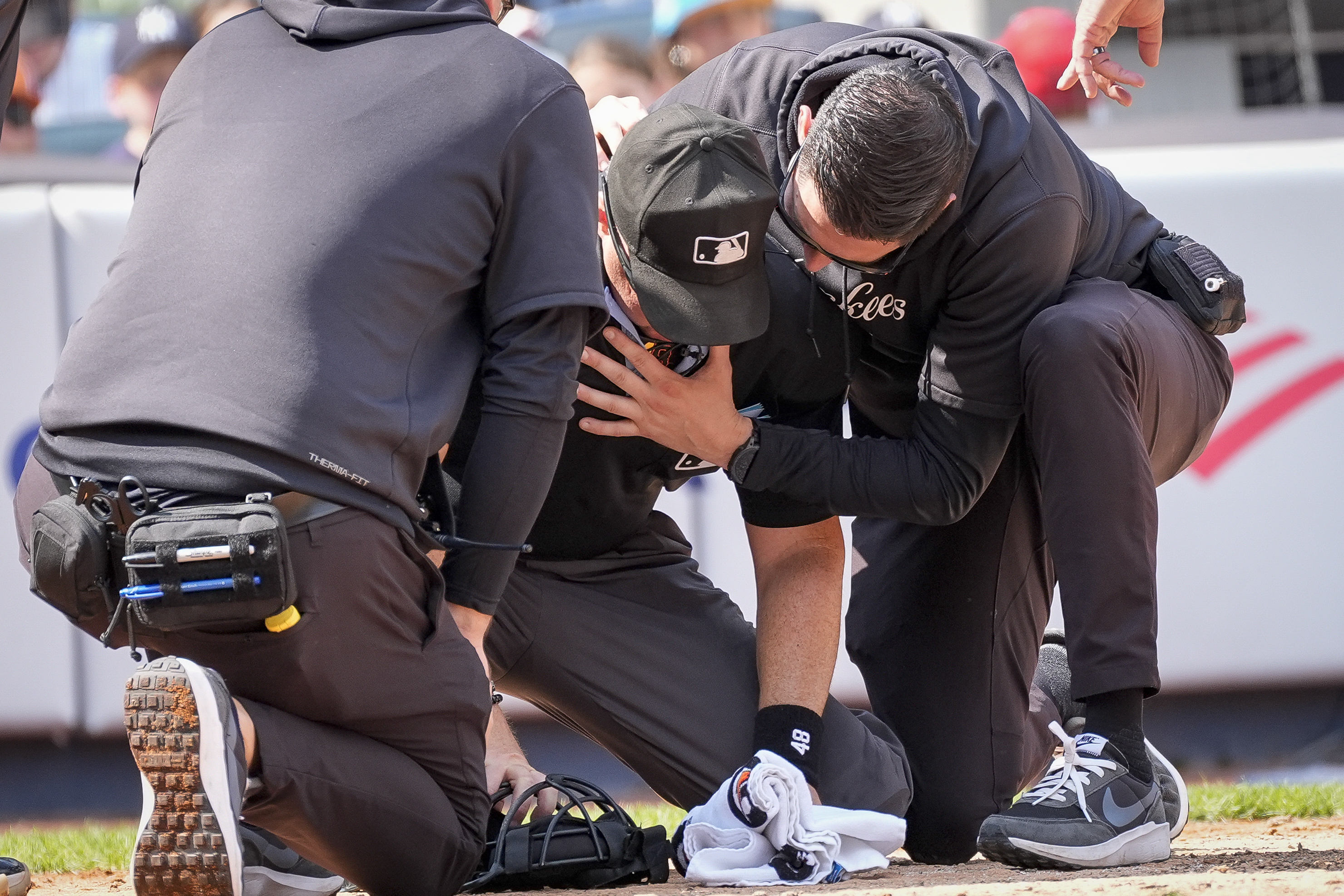 Medical staff tend to umpire Nick Mahrley, center, after he was hit by a bat during the fifth inning of a baseball game between the Colorado Rockies and the New York Yankees, Sunday, Aug. 25, 2024, in New York. 
