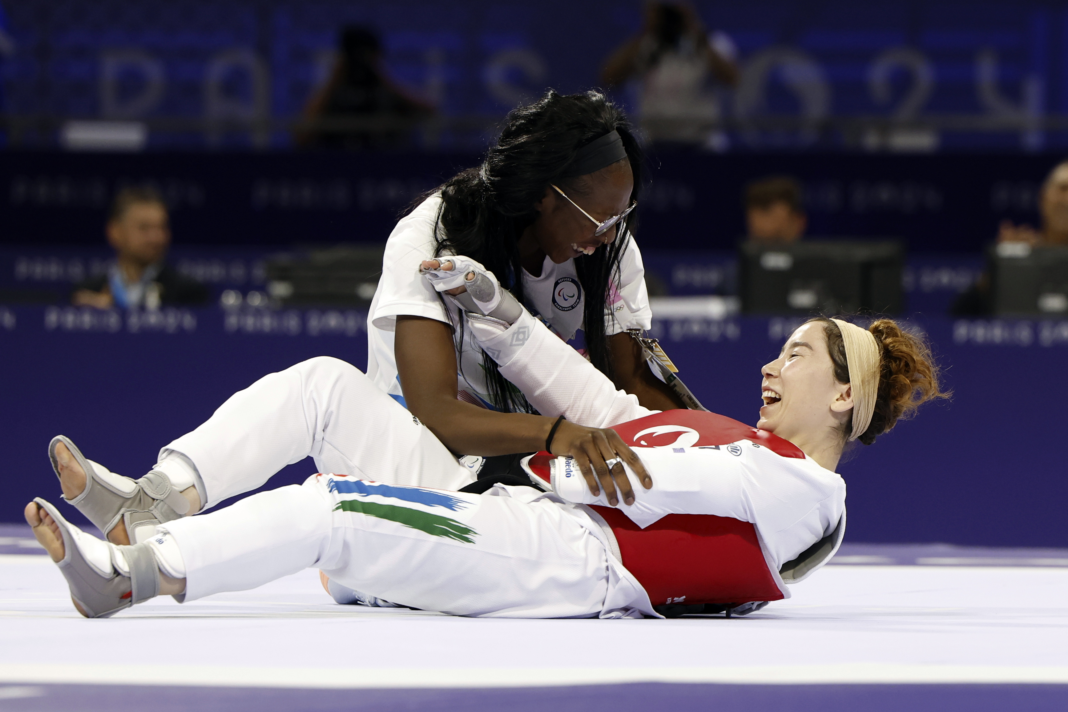 Zakia Khudadadi from the Paralympic Refugee Team, bottom, celebrates her bronze medal in Para Taekwondo during the Paralympic Games in Paris, Thursday, Aug. 29, 2024. 