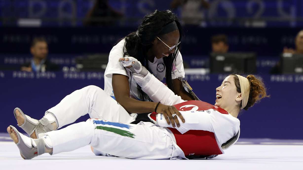 Zakia Khudadadi from the Paralympic Refugee Team, bottom, celebrates her bronze medal in Para Taekwondo during the Paralympic Games in Paris, Thursday, Aug. 29, 2024.