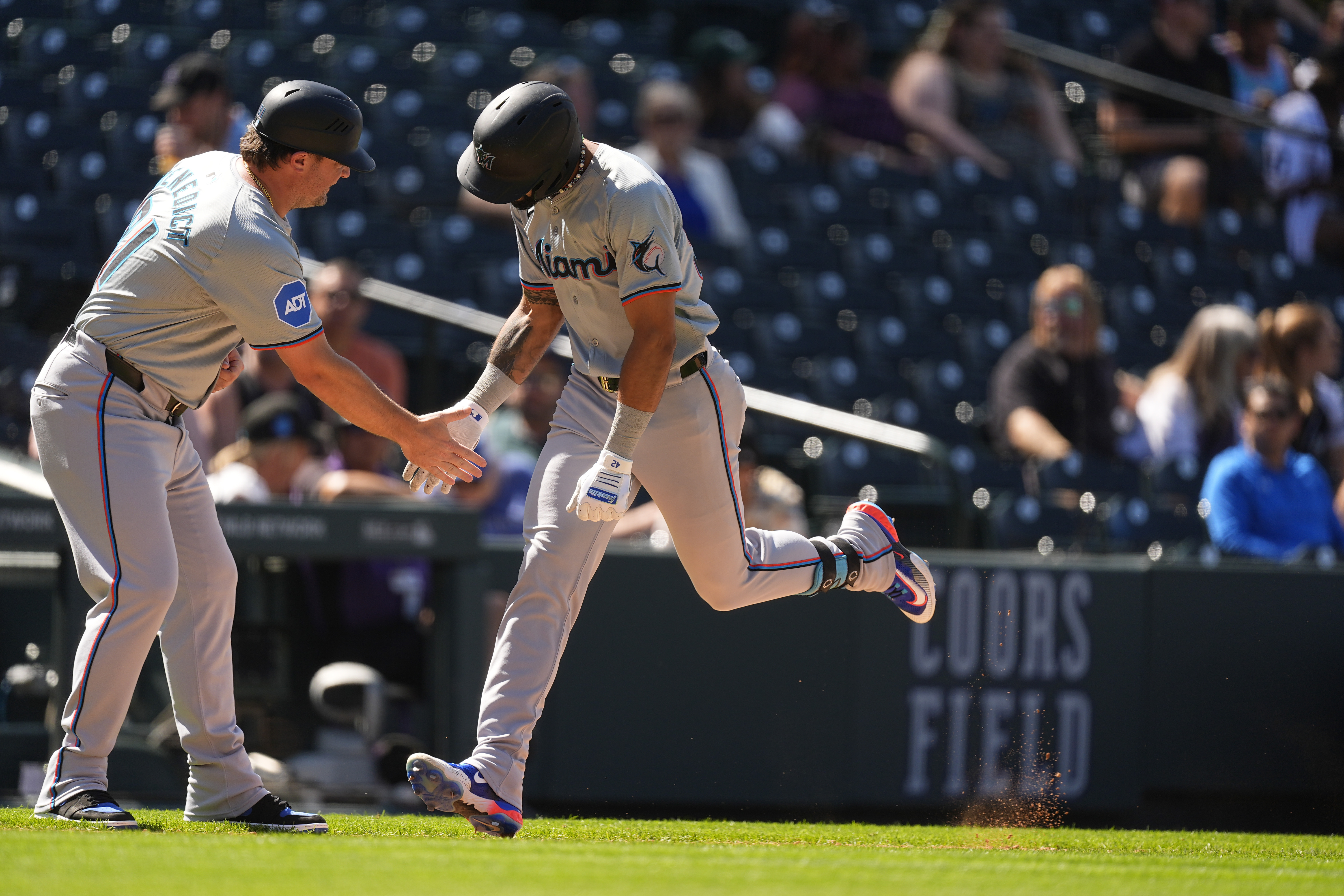 Miami Marlins third base coach Griffin Benedict, left, congratulates Derek Hill as he circles the bases after hitting a two-run home run off Colorado Rockies relief pitcher Noah Davis in the sixth inning of a baseball game Thursday, Aug. 29, 2024, in Denver. 
