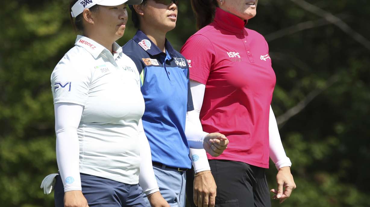 Megan Khang of the United States, left, Yuka Saso of Japan, center, and Hannah Green, right, of Australia walk together onto the 3rd tee during the first round of the FM championship LPGA golf tournament, Thursday, Aug. 29, 2024, at TPC Boston in Norton, Mass.