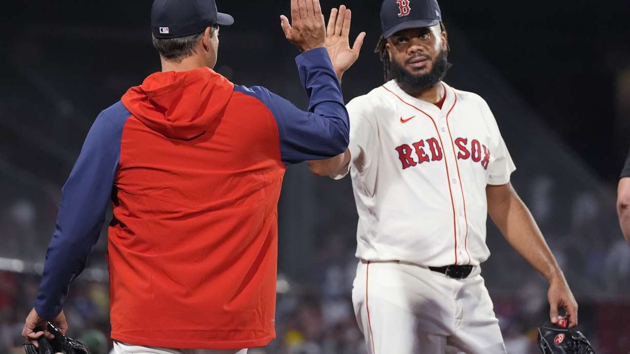 Boston Red Sox pitcher Kenley Jansen is congratulated by pitcher Rich Hill, left, after defeating the Toronto Blue Jays in a baseball game at Fenway Park, Tuesday, Aug. 27, 2024, in Boston.