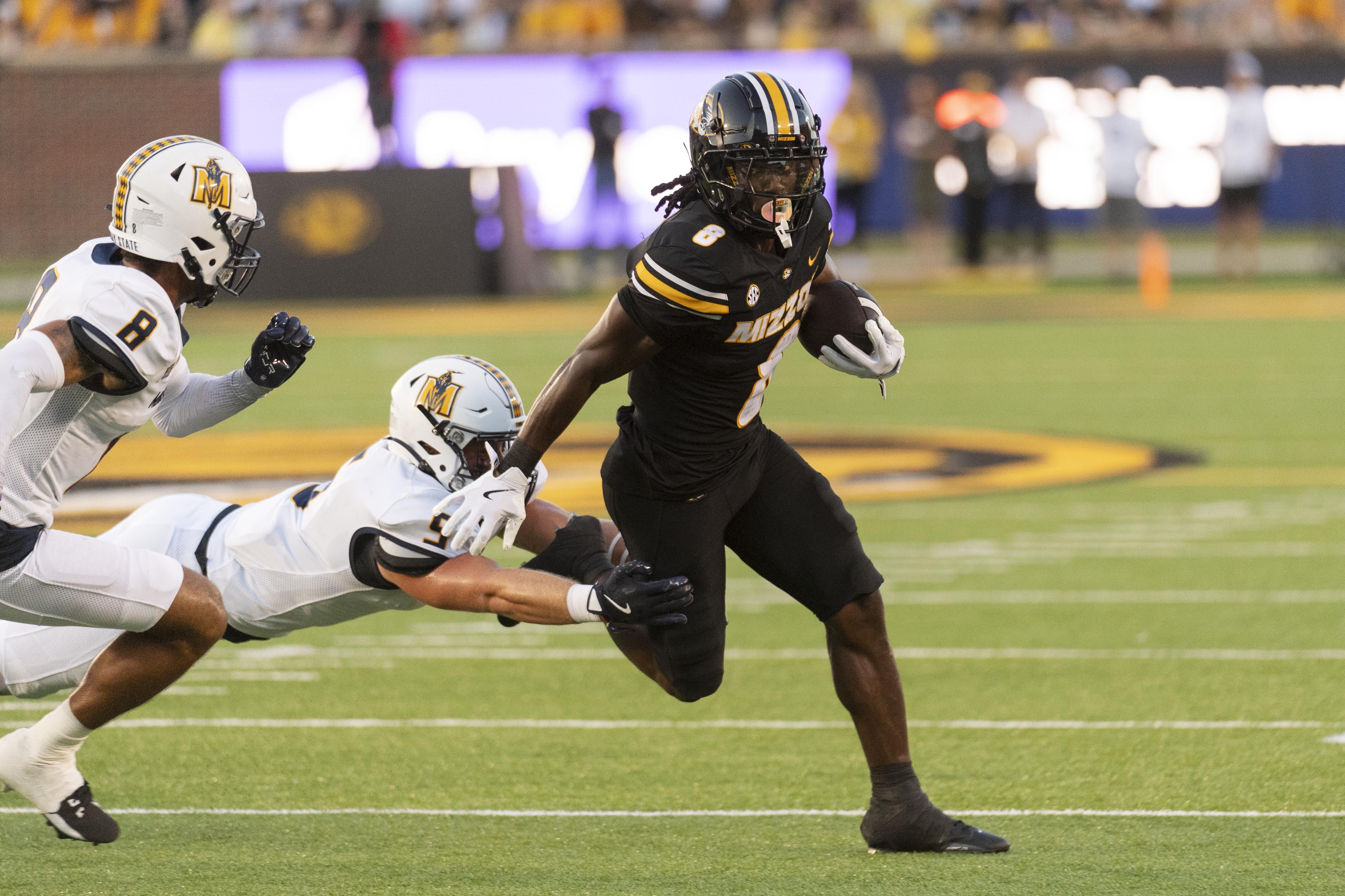 Missouri running back Nate Noel, right, runs past Murray State linebacker James Camden, center, during the first quarter of an NCAA college football game Thursday, Aug. 29, 2024, in Columbia, Mo. 