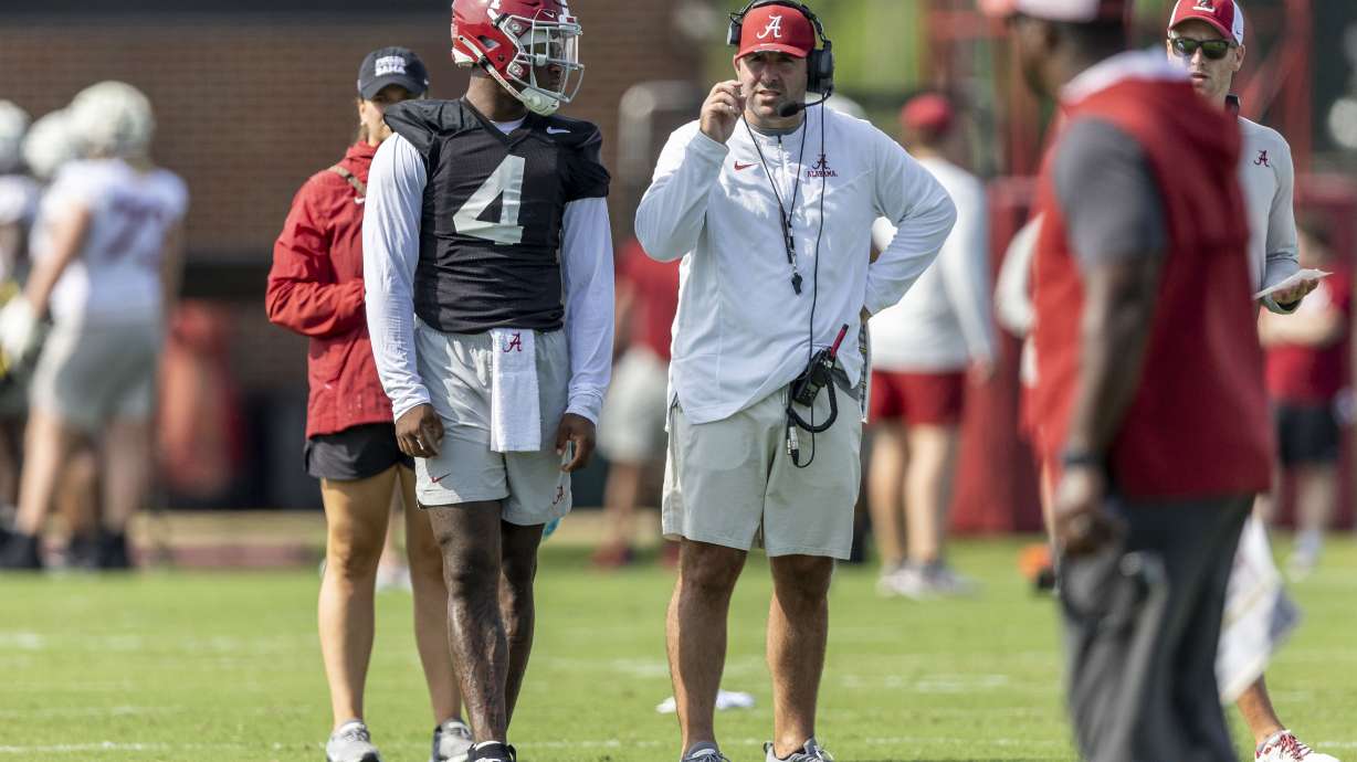Alabama offensive coordinator Nick Sheridan coaches quarterback Jalen Milroe (4) during NCAA college football practice, Wednesday, July 31, 2024, at the Thomas-Drew Practice Fields in Tuscaloosa, Ala.
