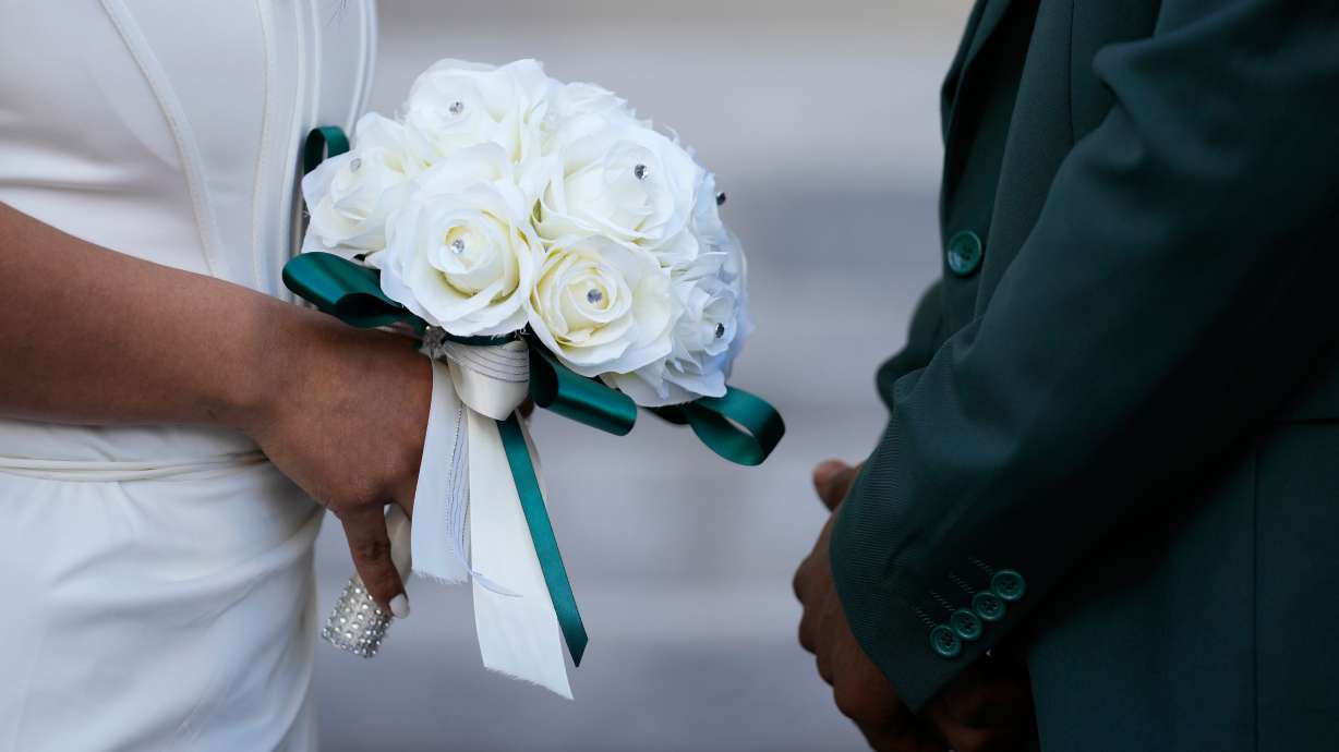 A couple stands facing each other during a Valentine's Day group wedding ceremony on the steps of the Dade County Courthouse in Miami, Feb. 14. Rising wedding costs have couples innovating options for funds.