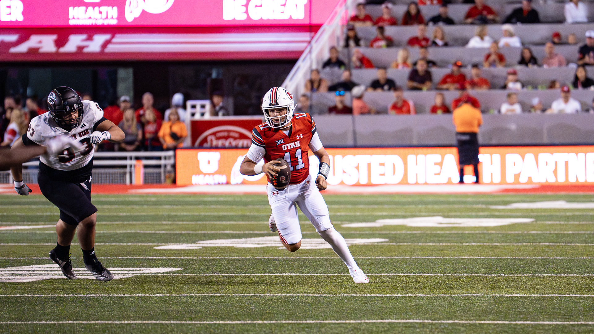 Utah freshman quarterback Isaac Wilson rolls out of the pocket to evade defenders in a game against Southern Utah on Aug. 29, 2024 in Salt Lake City.