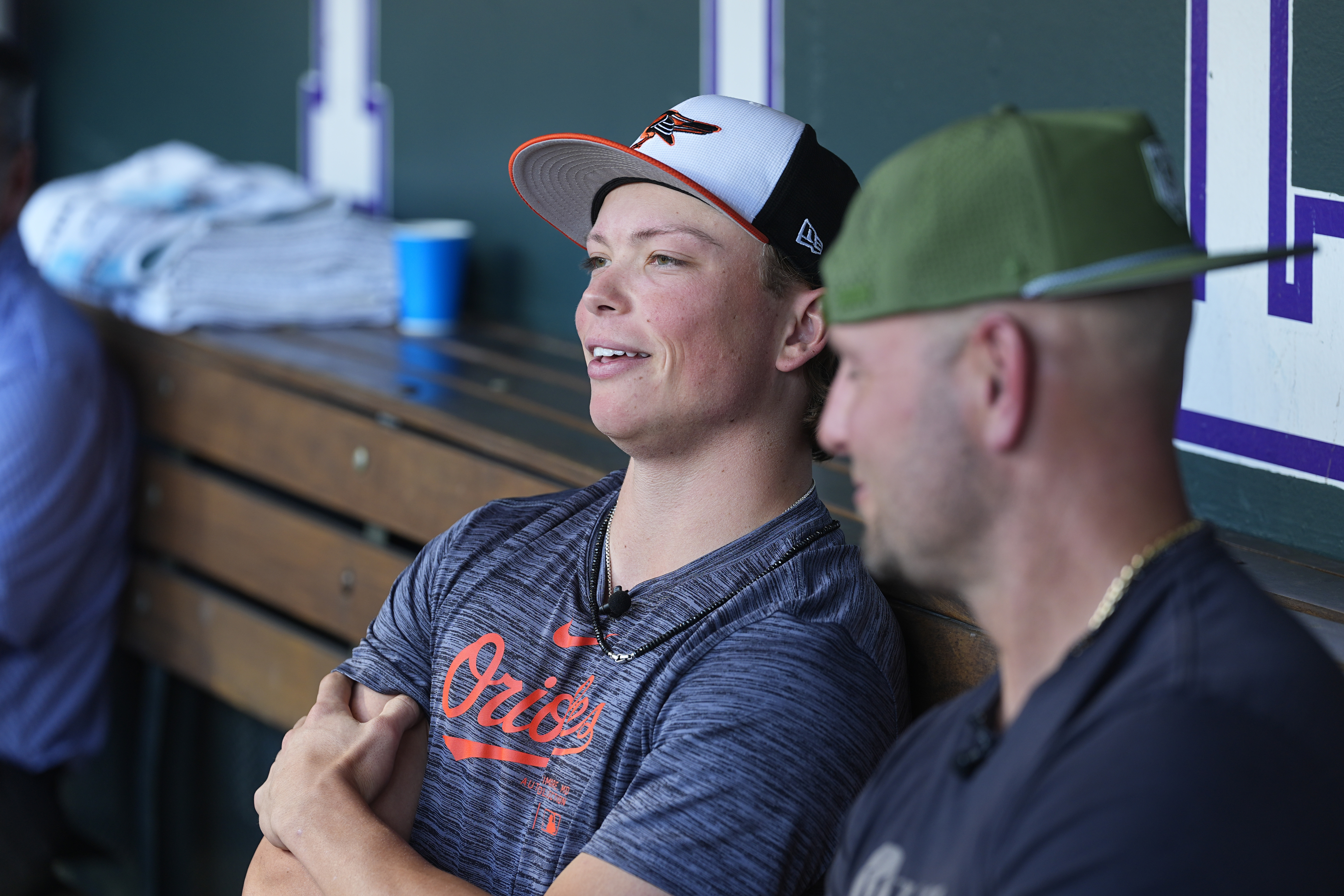 Retired Major League Baseball player Matt Holliday, front, listens as his son, Jackson, second baseman for the Baltimore Orioles, talks to reporters before the Orioles face the Colorado Rockies in a baseball game Friday, Aug. 30, 2024, in Denver. 