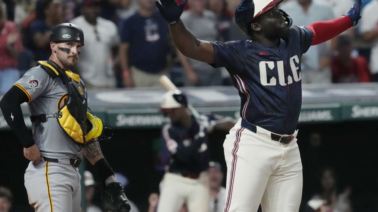 Cleveland Guardians' Jhonkensy Noel, right, celebrates in front of Pittsburgh Pirates catcher Yasmani Grandal, left, after hitting a home run in the fifth inning of a baseball game, Friday, Aug. 30, 2024, in Cleveland.