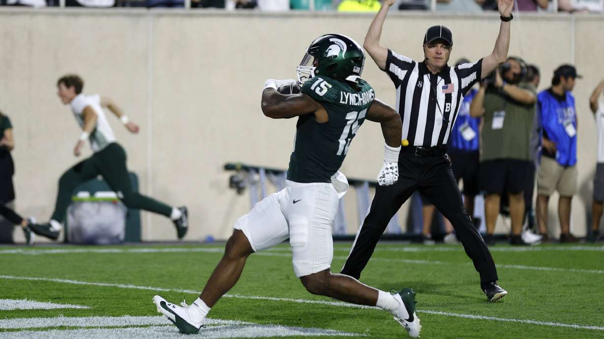 Michigan State running back Kay'Ron Lynch-Adams (15) scores on a rushing touchdown during the second quarter of an NCAA college football game, Friday, Aug. 30, 2024, in East Lansing, Mich.