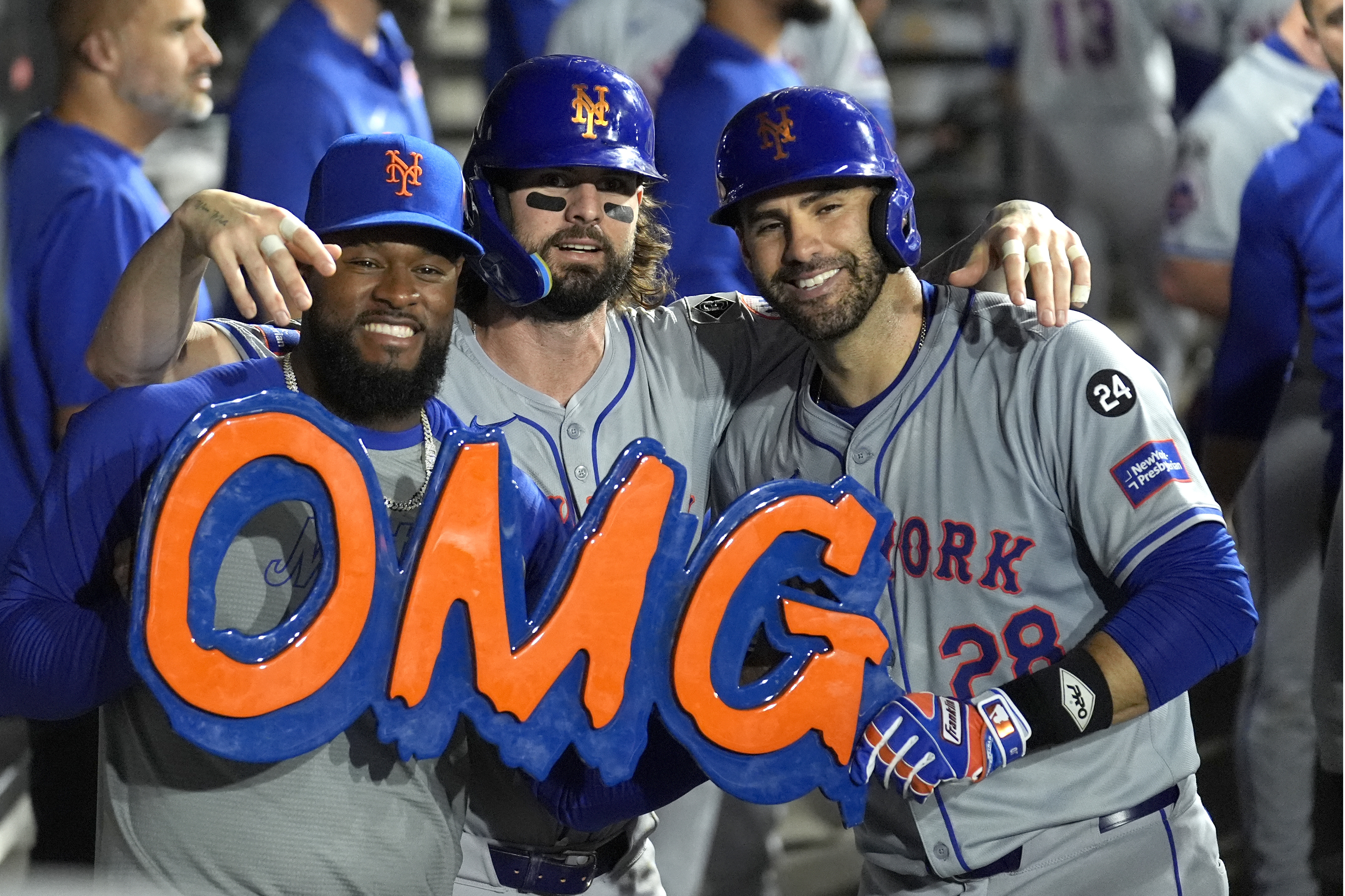 The New York Mets from left, Luis Severino, Jesse Winker, and J.D. Martinez, celebrate in the dugout for TV cameras, Martinez's two-run home run off Chicago White Sox pitcher Jonathan Cannon during the third inning of a baseball game Friday, Aug. 30, 2024, in Chicago. 