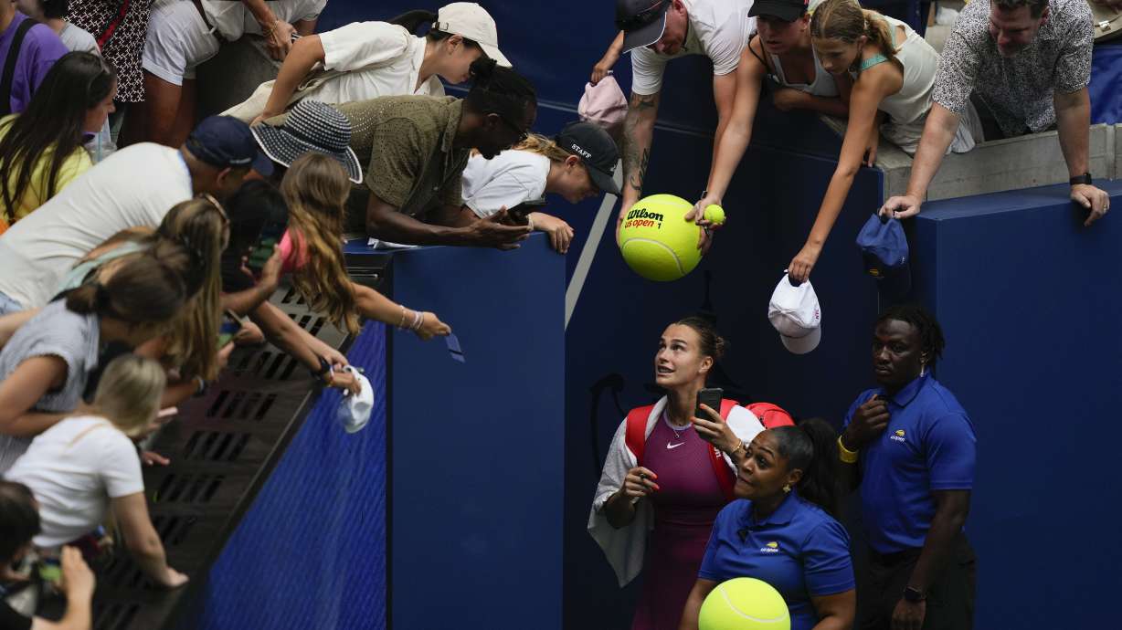 Aryna Sabalenka, of Belarus, signs autographs for fans after defeating Lucia Bronzetti, of Italy, during the second round of the U.S. Open tennis championships, Wednesday, Aug. 28, 2024, in New York.