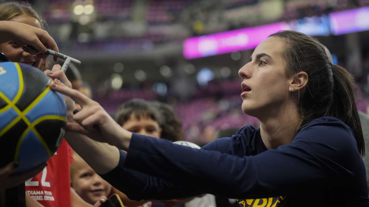 Indiana Fever's Caitlin Clark signs autographs for fans before a WNBA basketball game against the Chicago Sky, Friday, Aug. 30, 2024, in Chicago.