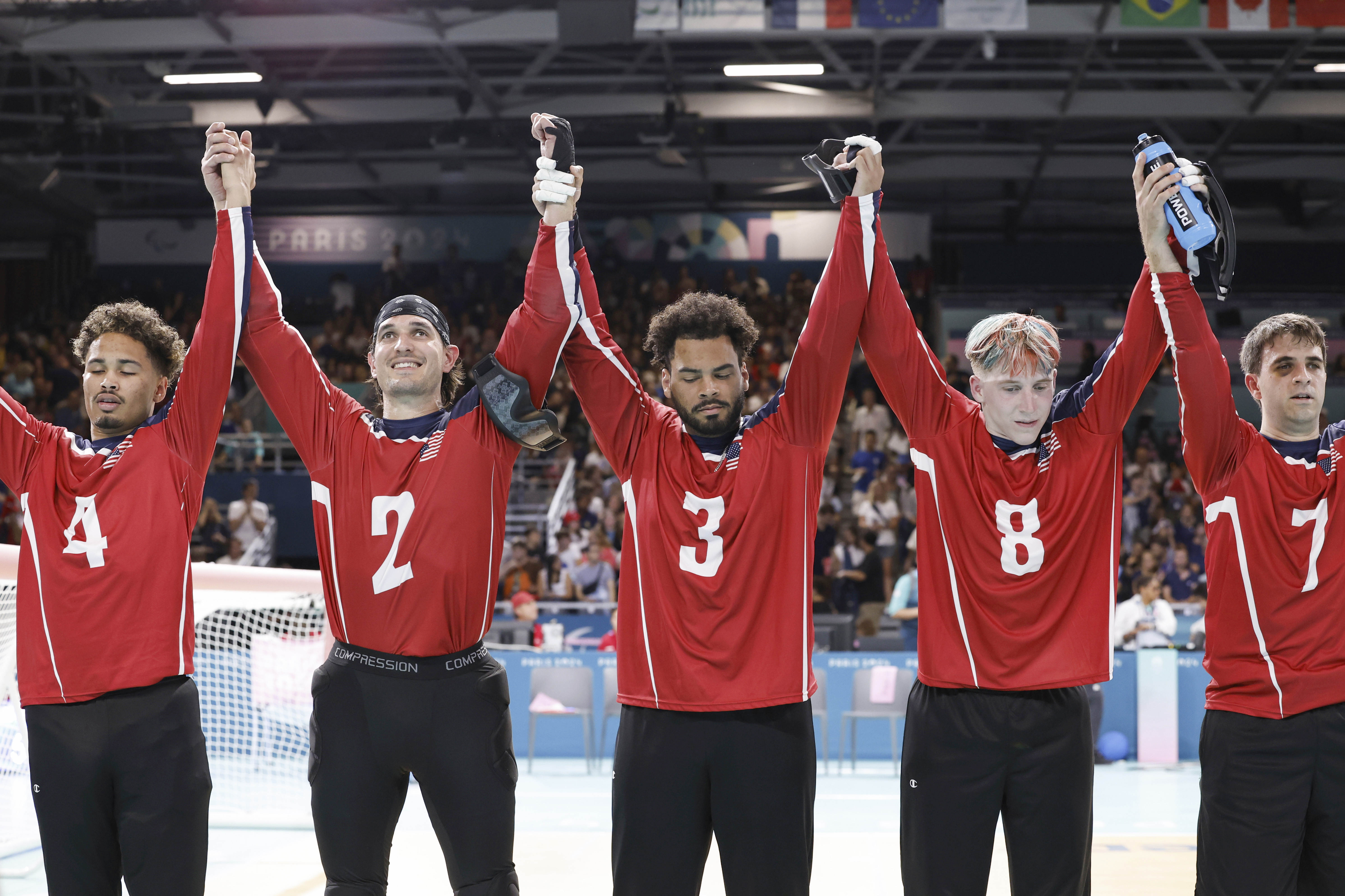 From left, U.S. team goalball players Tre'shaun Faison, Tyler Merren, Zion Walker, Christian King and Matt Simpson raise their hands after a 5-4 victory over the French men's goalball team during the Paralympic Games in Paris, Saturday, Aug. 31, 2024. 