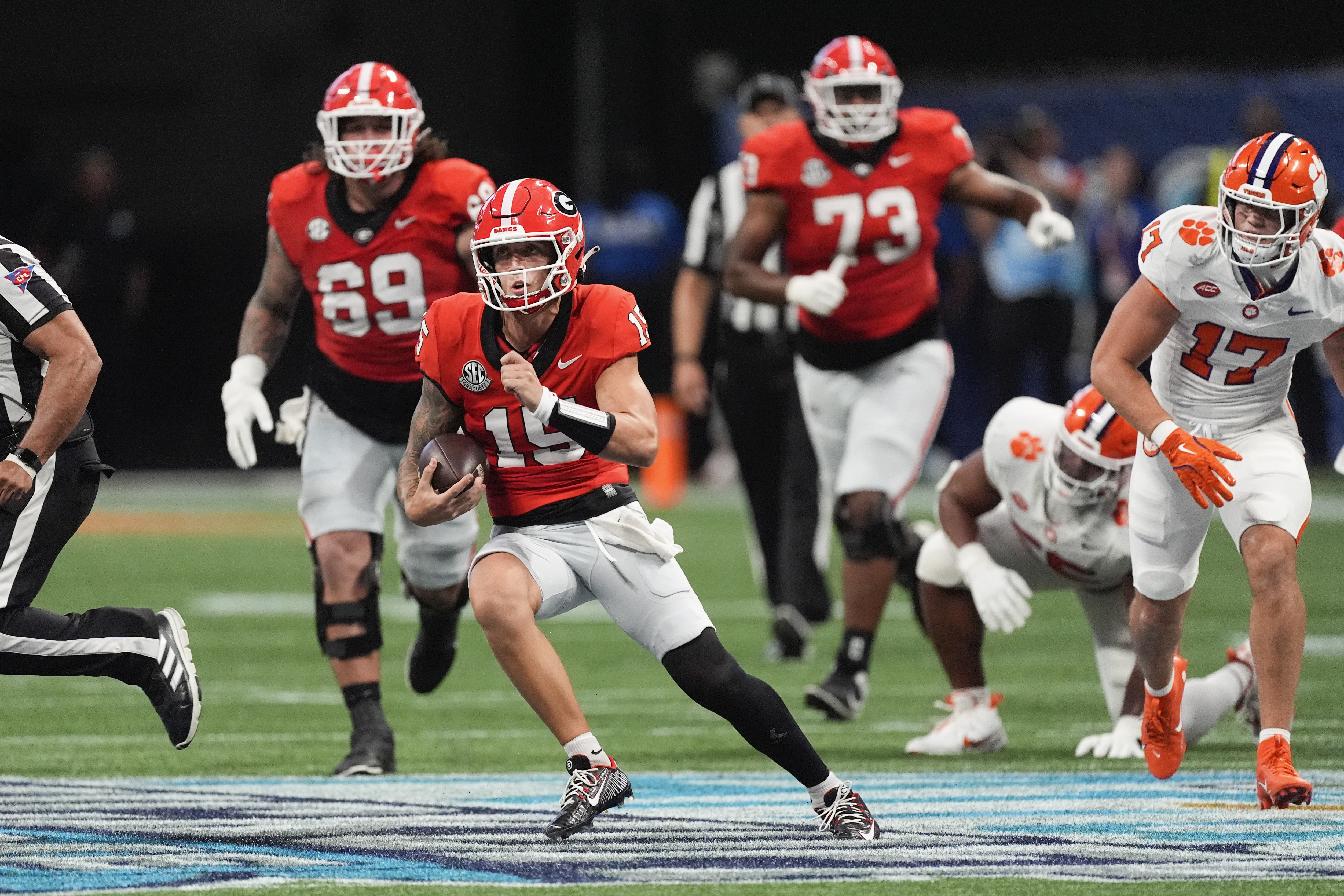 Georgia quarterback Carson Beck (15) looks for running room as Clemson linebacker Wade Woodaz (17) gives chase during the first half of an NCAA college football game Aug. 31, 2024, in Atlanta. 