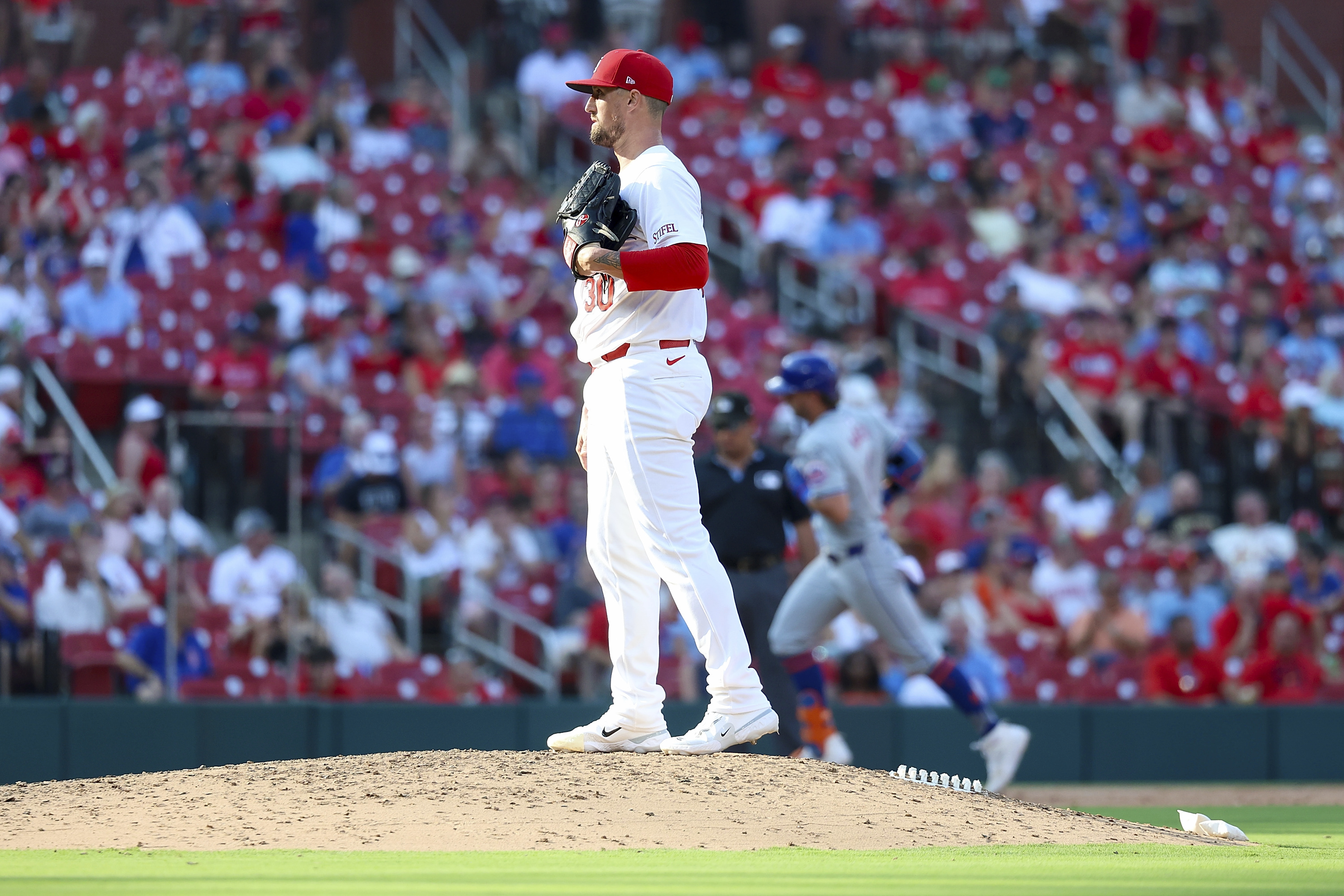 St. Louis Cardinals relief pitcher Shawn Armstrong pauses on the mound after giving up a solo home run to New York Mets' Jeff McNeil, back right, during the sixth inning of a baseball game Monday, Aug. 5, 2024, in St. Louis. 