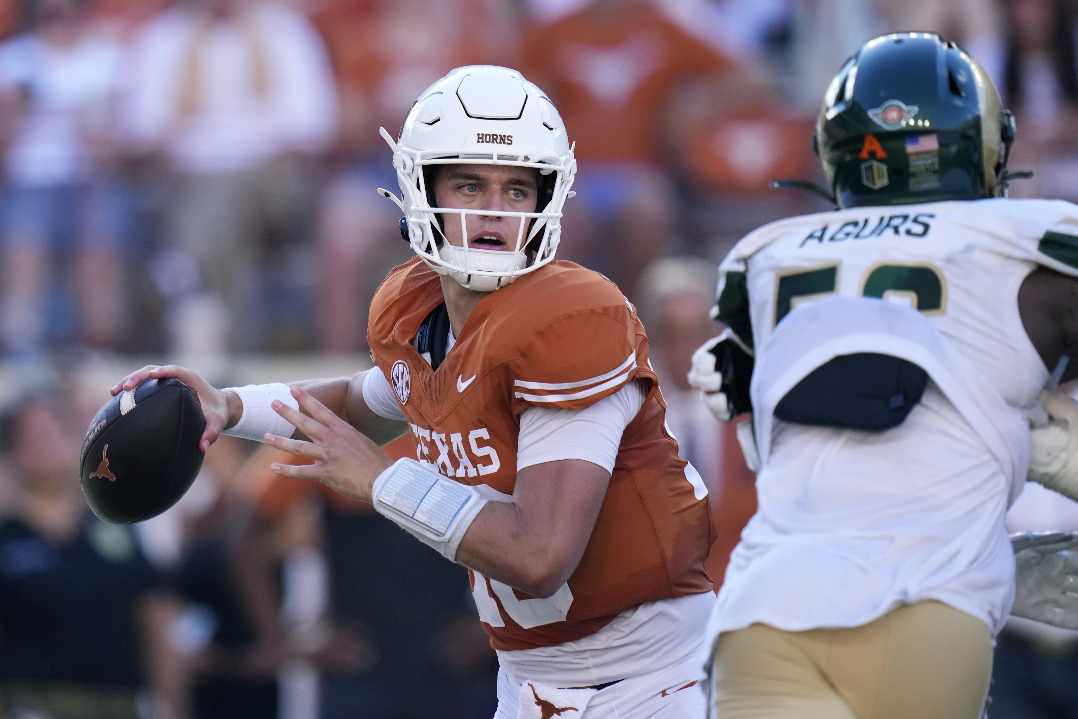 Texas quarterback Arch Manning, left, throws against Colorado State during the second half of an NCAA college football game in Austin, Texas, Saturday, Aug. 31, 2024. 