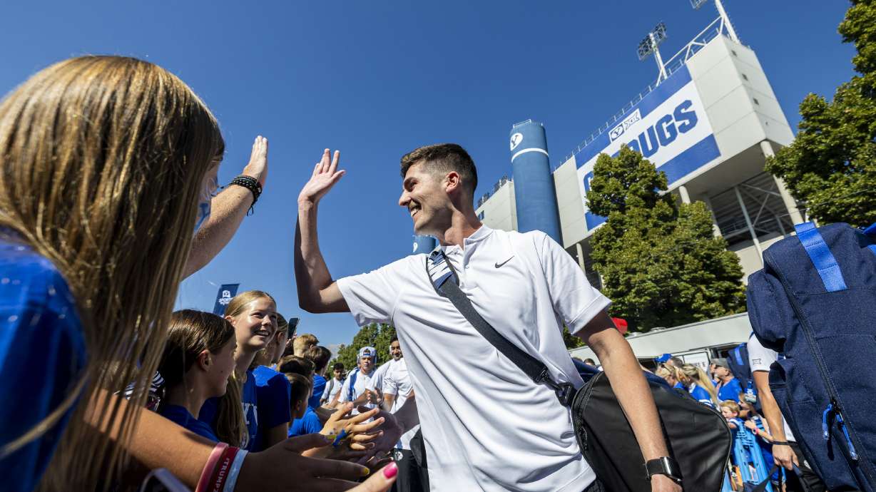Brigham Young University kicker Will Ferrin slaps hands with fans as he and his teammates make their way through Cougar Canyon before the home opener of the Brigham Young University Cougars held against the Southern Illinois University Salukis at LaVell Edwards Stadium in Provo on Saturday, Aug. 31, 2024.
