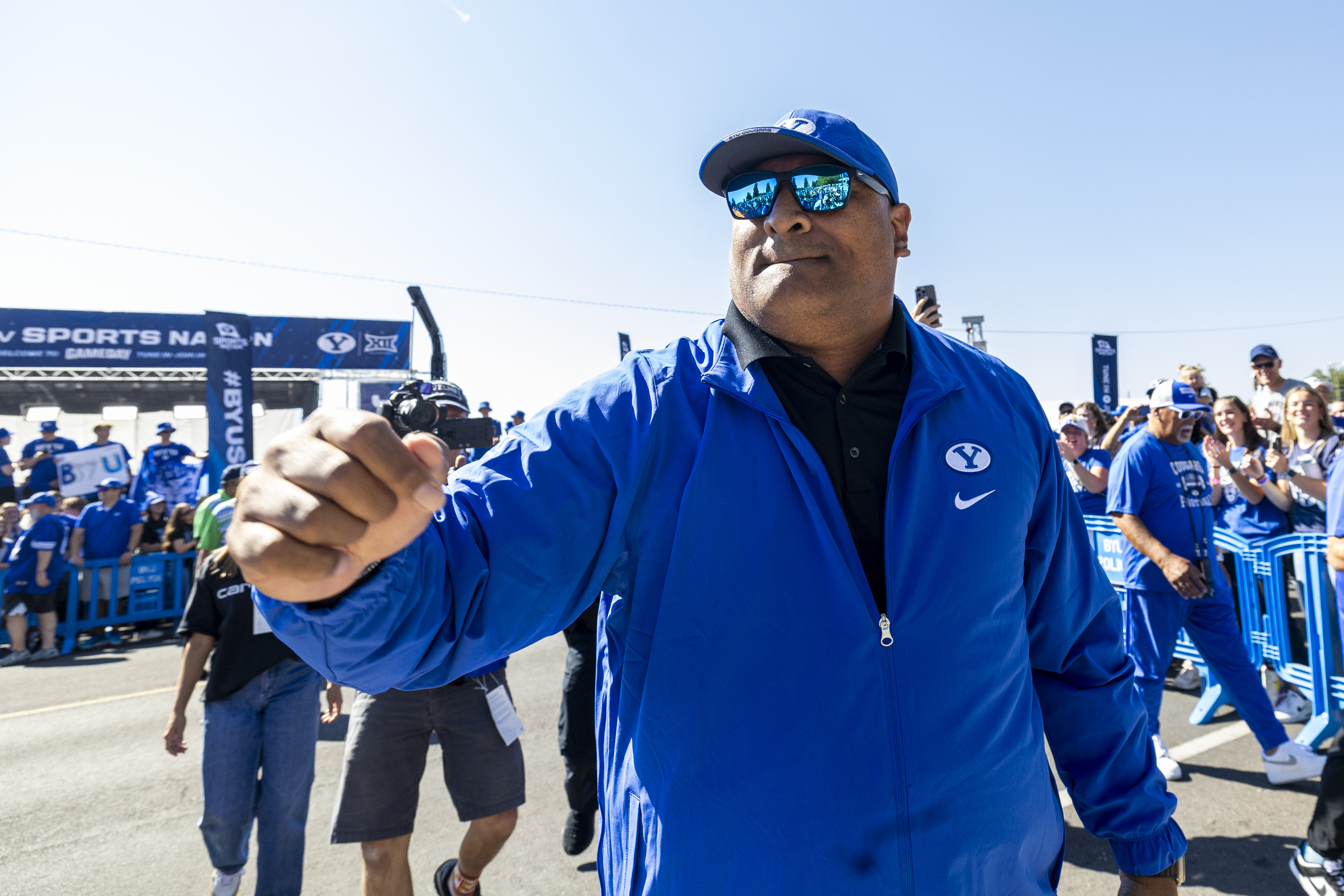 Brigham Young head coach Kalani Sitake slaps hands with fans as he and his teammates make their way through Cougar Canyon before the home opener of the Brigham Young University Cougars held against the Southern Illinois University Salukis at LaVell Edwards Stadium in Provo on Saturday, Aug. 31, 2024.