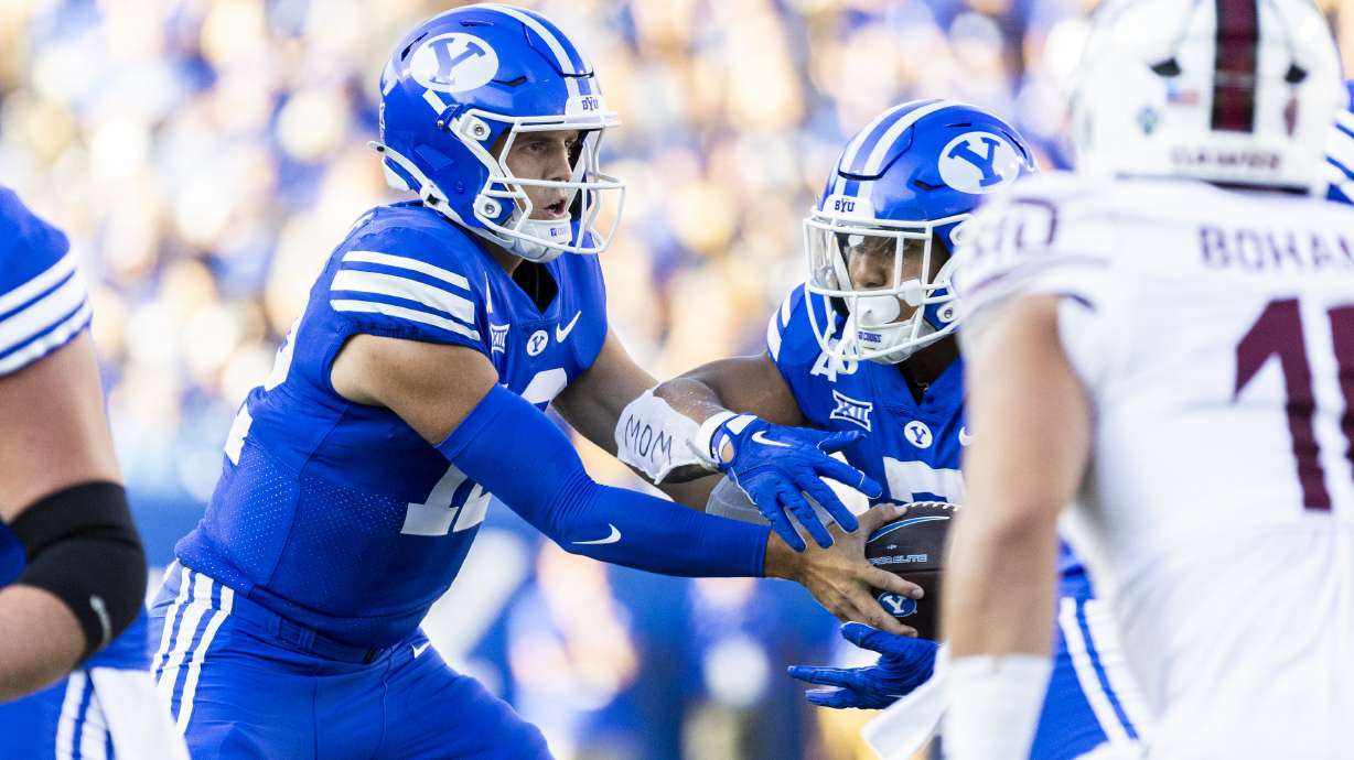 Brigham Young quarterback Jake Retzlaff (12) hands the ball off to running back Folau Ropati (7) during BYU’s home opener against Southern Illinois University held at LaVell Edwards Stadium in Provo on Saturday, Aug. 31, 2024.
