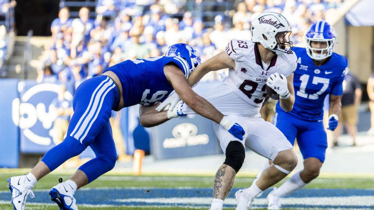 Brigham Young defensive end Tyler Batty (92) takes down Southern Illinois tight end Ryan Schwendeman (83) during BYU’s home opener held at LaVell Edwards Stadium in Provo on Saturday, Aug. 31, 2024.