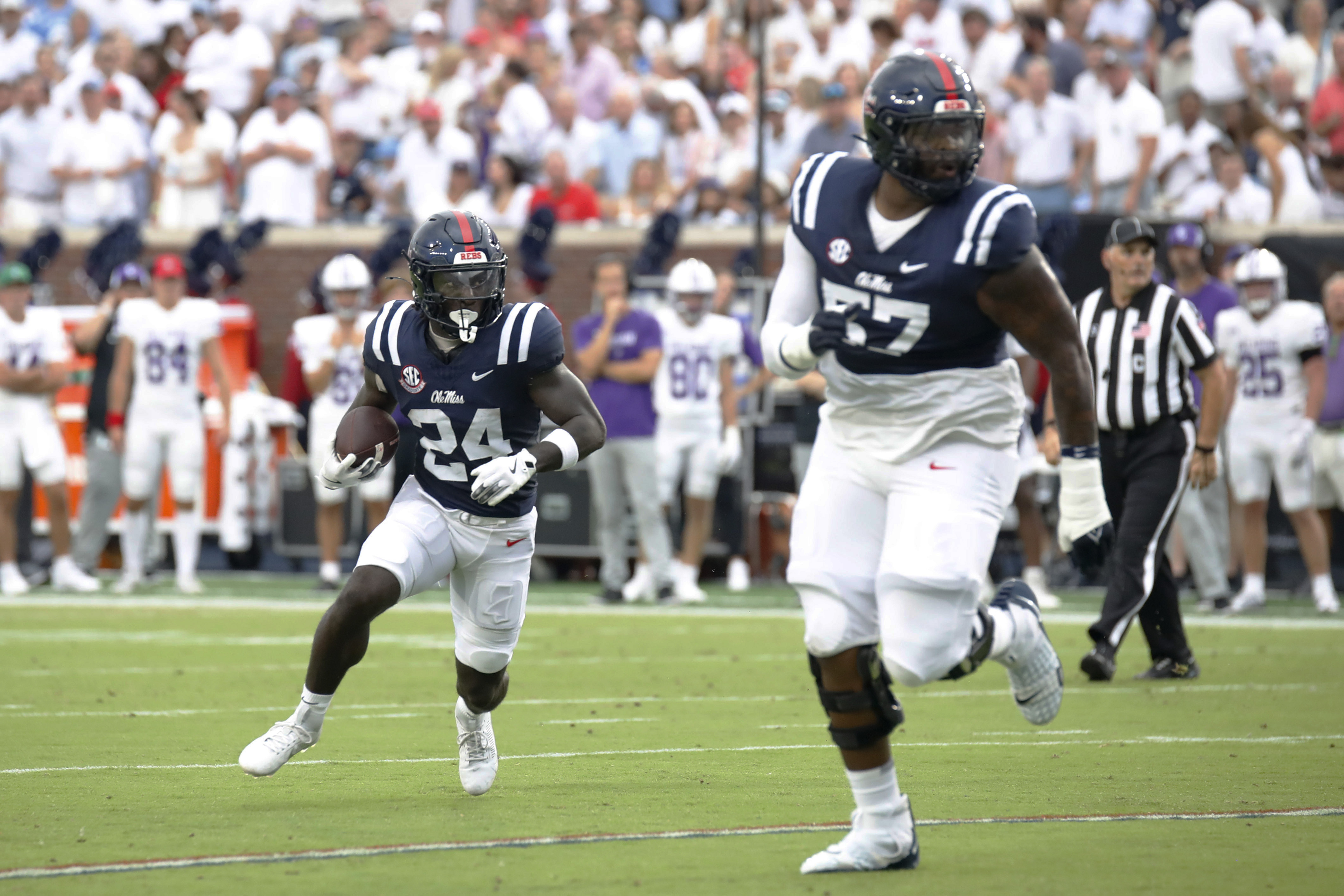 Mississippi running back Ulysses Bentley IV (24) runs the ball, while offensive lineman Micah Pettus (57) guards, during the first half of an NCAA college football game, against Furman, Saturday, Aug. 31, 2024, in Oxford, Miss. 