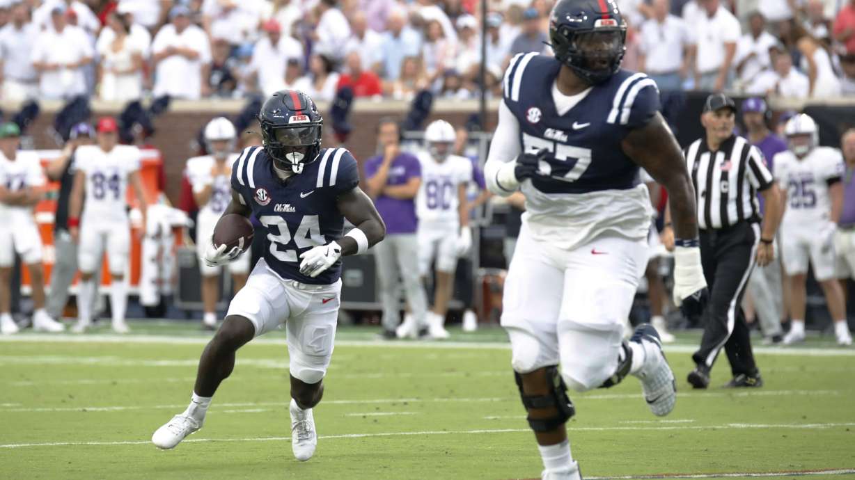 Mississippi running back Ulysses Bentley IV (24) runs the ball, while offensive lineman Micah Pettus (57) guards, during the first half of an NCAA college football game, against Furman, Saturday, Aug. 31, 2024, in Oxford, Miss.