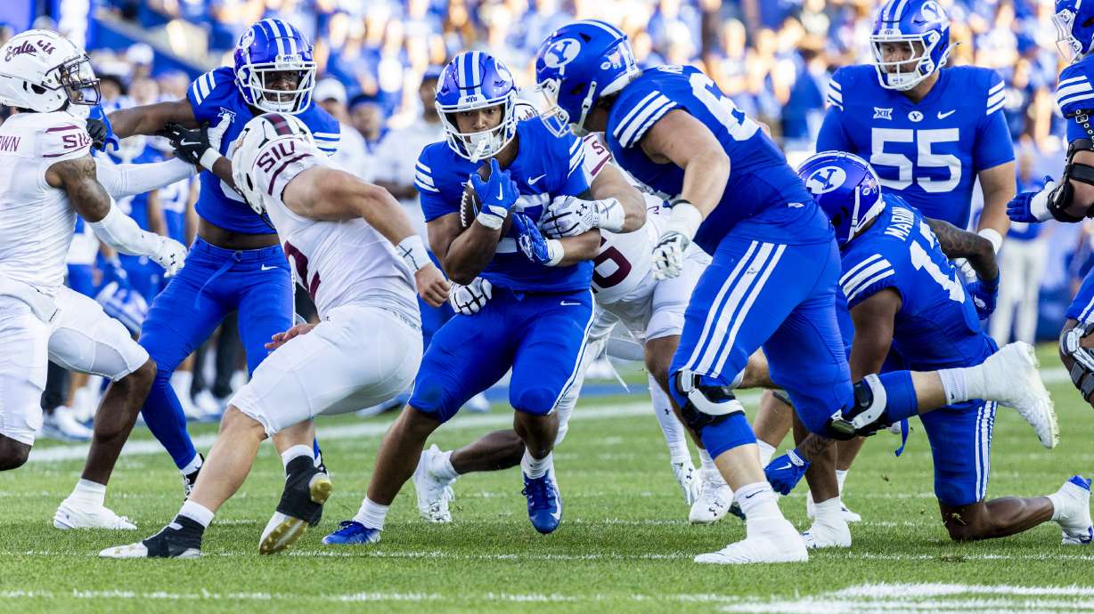 Brigham Young running back LJ Martin (27) runs with the ball before being downed by Southern Illinois linebacker Colin Bohanek (16) during BYU’s home opener held at LaVell Edwards Stadium in Provo on Saturday, Aug. 31, 2024.