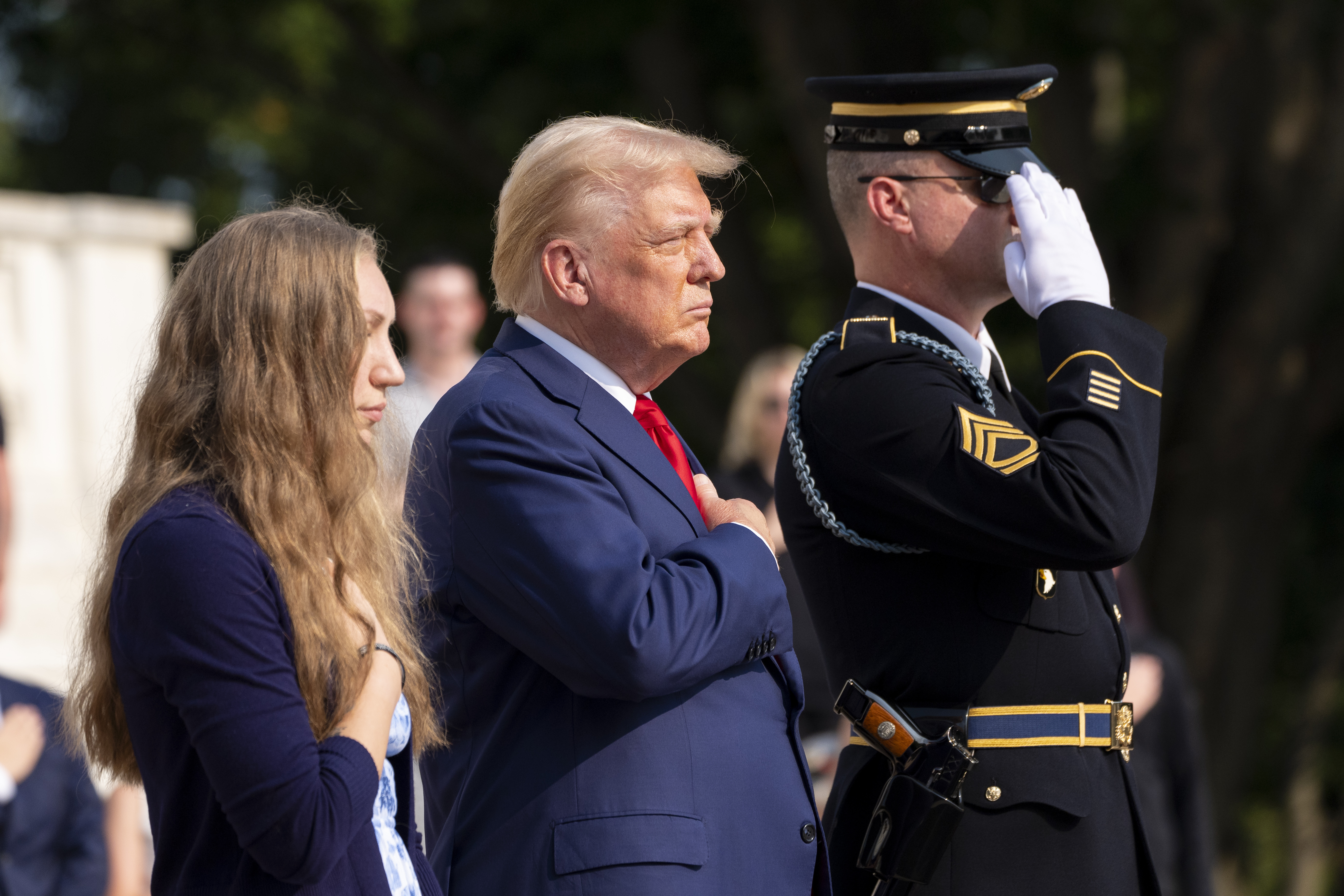 Misty Fuoco, left, sister of Nicole Gee, and Republican presidential nominee former President Donald Trump place their hands over their heart after placing a wreath in honor of Sgt. Nicole Gee, at the Tomb of the Unknown Solider at Arlington National Cemetery, Aug. 26, in Arlington, Va. 