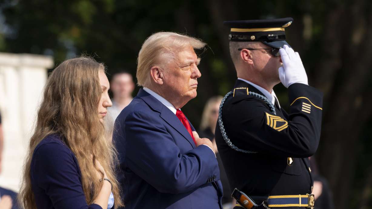 Misty Fuoco, left, sister of Nicole Gee, and Republican presidential nominee former President Donald Trump place their hands over their heart after placing a wreath in honor of Sgt. Nicole Gee, at the Tomb of the Unknown Solider at Arlington National Cemetery, Aug. 26, in Arlington, Va.